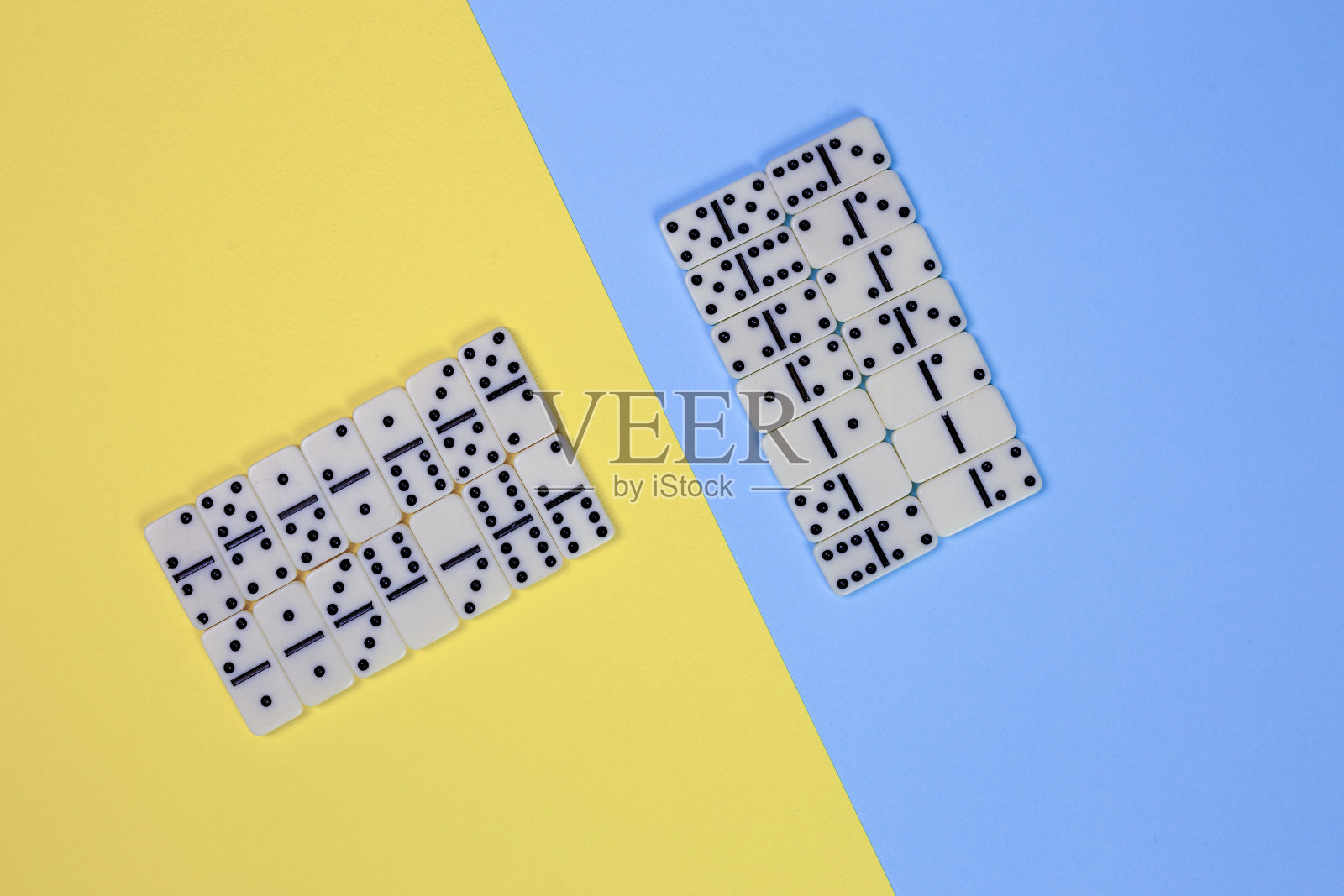 多米诺游戏概念，瓷砖组织与不同的策略在两种色调的黄色和蓝色表面照片摄影图片