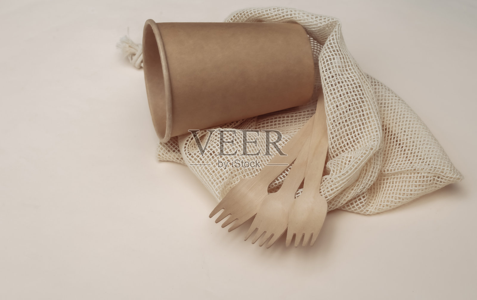 生态棉袋与木汤匙和纸板杯在米色背景。生态友好的概念。照片摄影图片