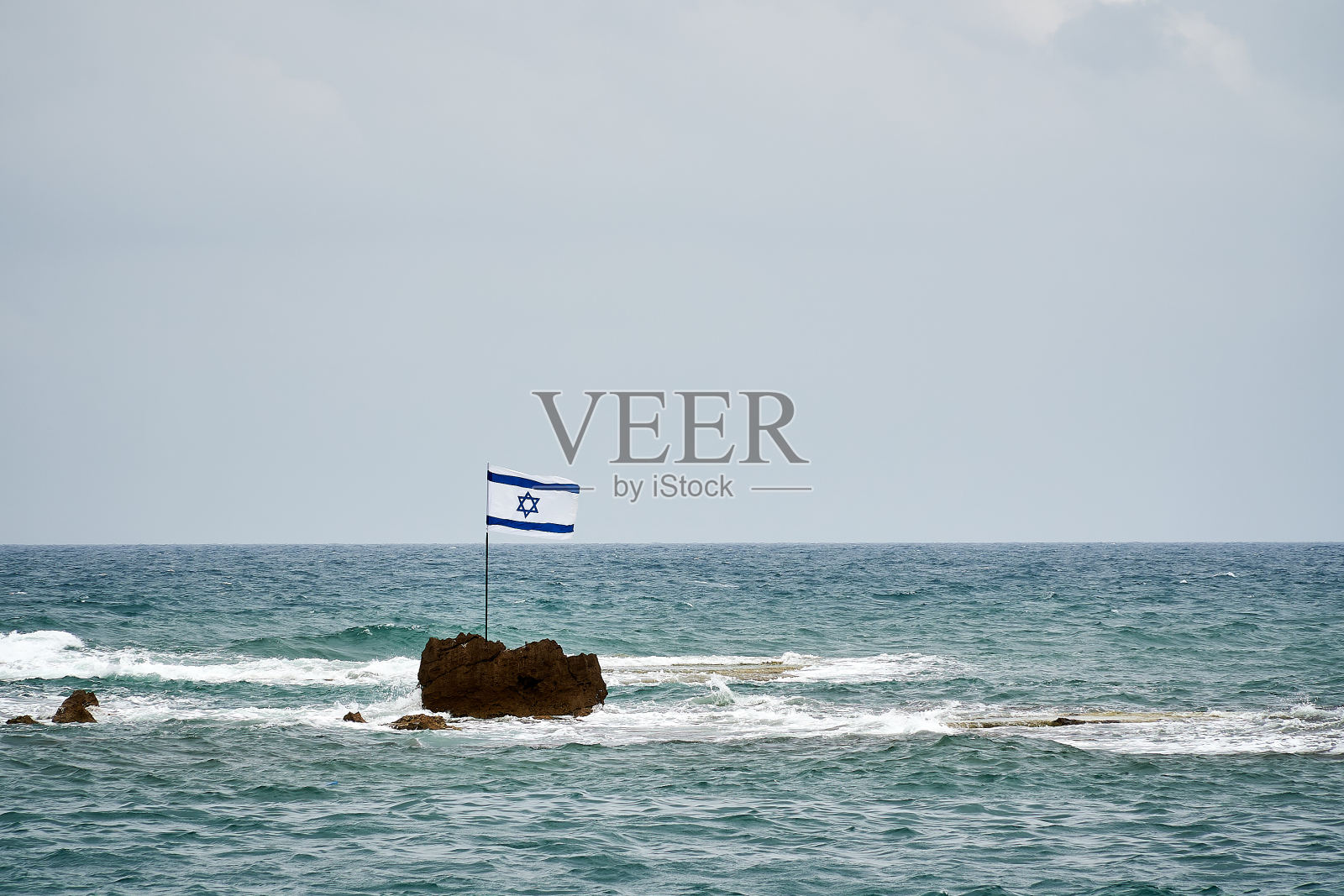 地中海岩石上的以色列国旗照片摄影图片