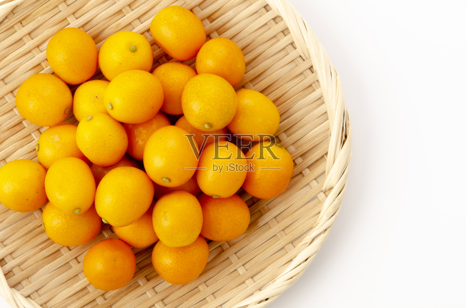 鲜金桔，竹筛上，白底照片摄影图片