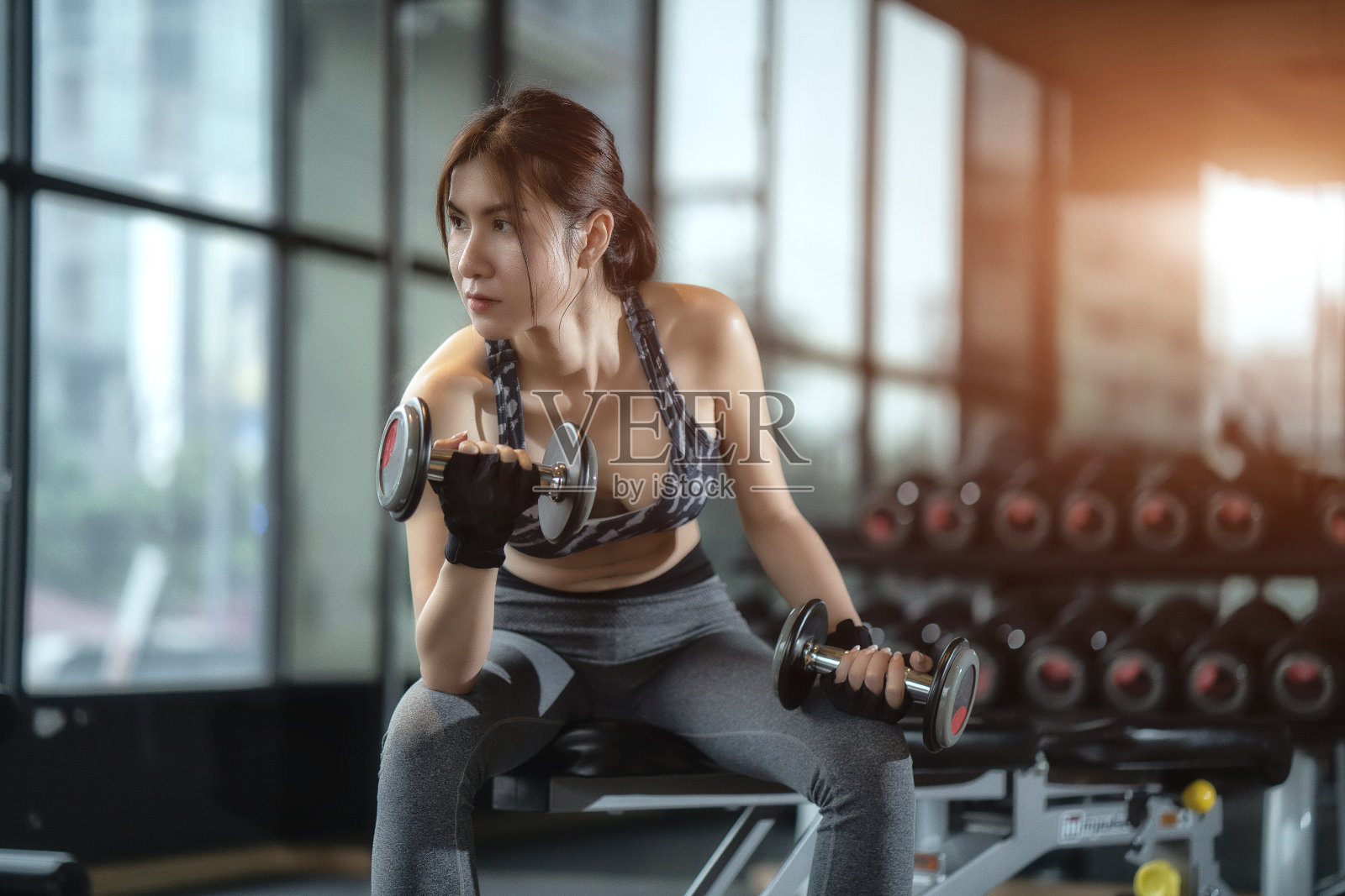 软焦点概念女性在健身房健身。美丽的女人通过照顾自己的身体来保持良好的身材。健康的概念。照片摄影图片