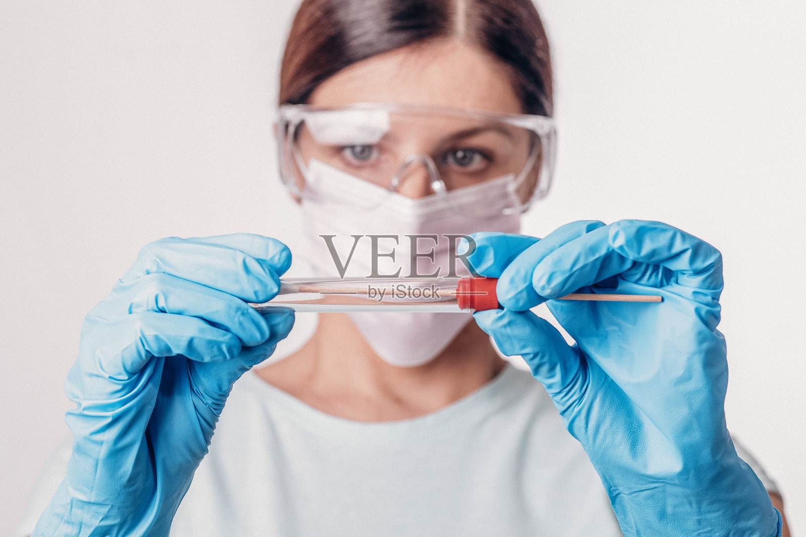 医生专家手持新型冠状病毒聚合酶链反应检测试剂盒。冠状病毒COVID-19拭子检测试剂盒，PPE防护口罩和手套，管取OP NP患者标本样本，DNA RNA协议流程照片摄影图片