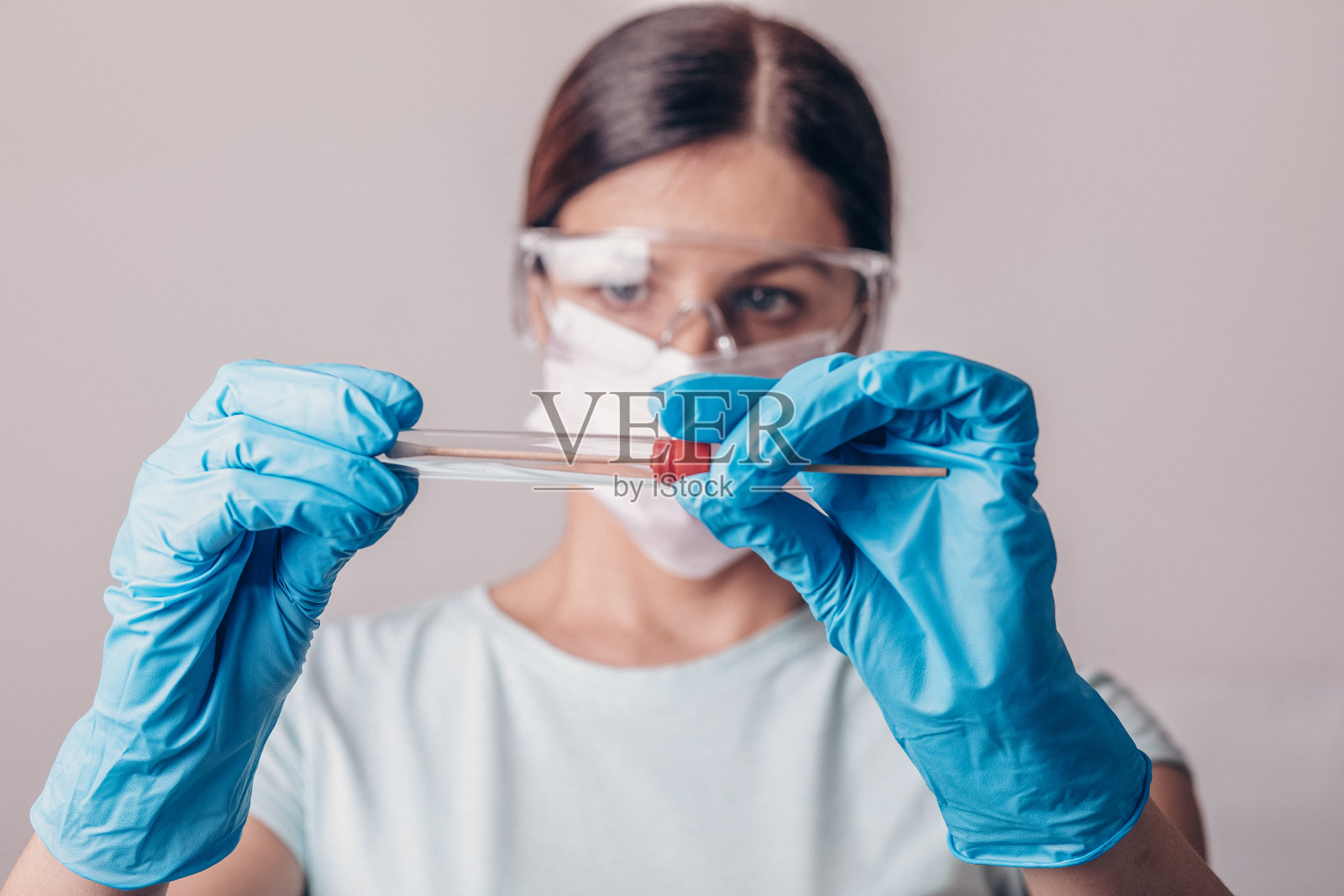 实验室技术员手持新型冠状病毒聚合酶链反应检测试剂盒。冠状病毒COVID-19拭子检测试剂盒，PPE防护口罩和手套，管取OP NP患者标本样本，DNA RNA协议流程照片摄影图片