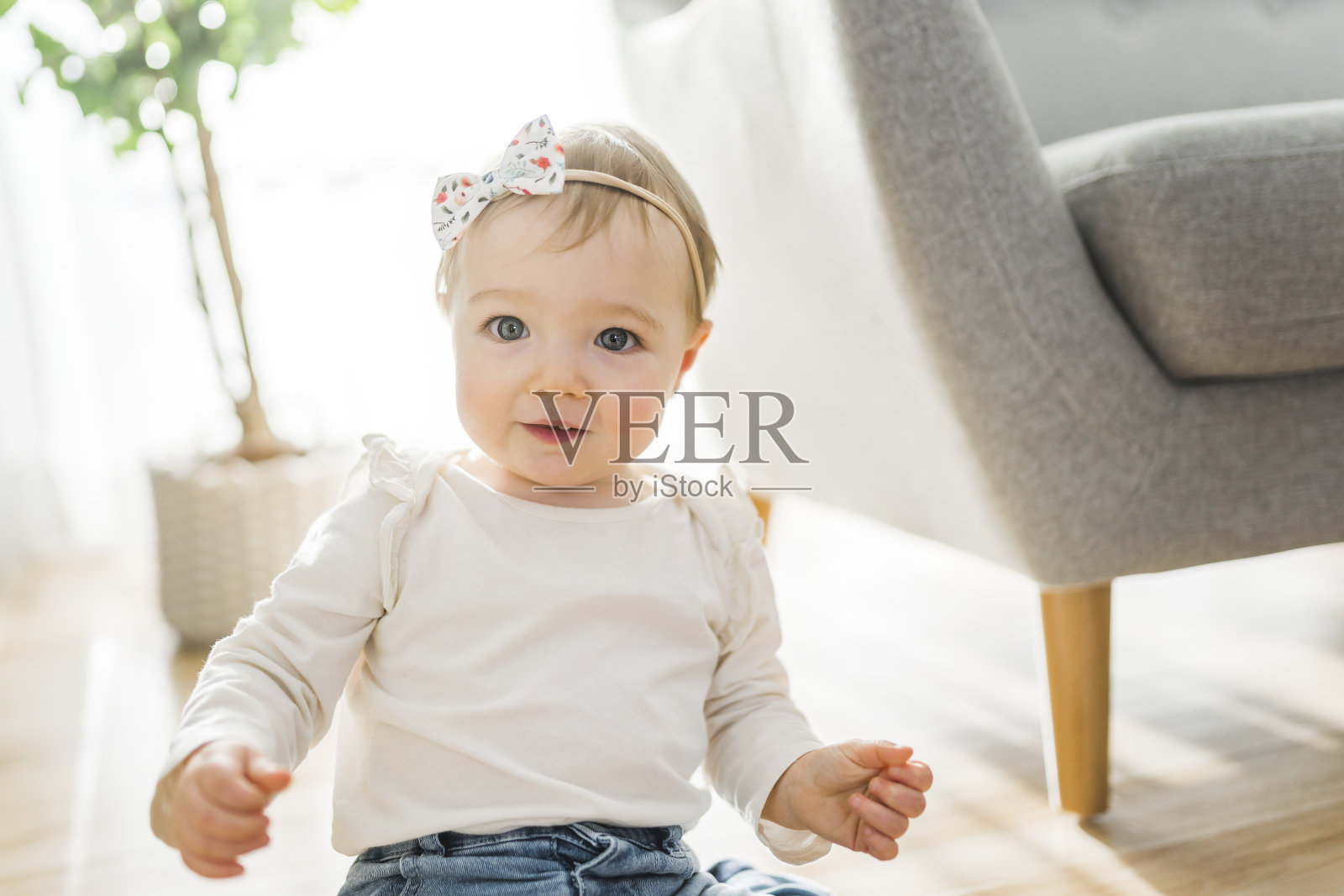 一个小女孩在客厅的沙发上玩耍的肖像，照片摄影图片