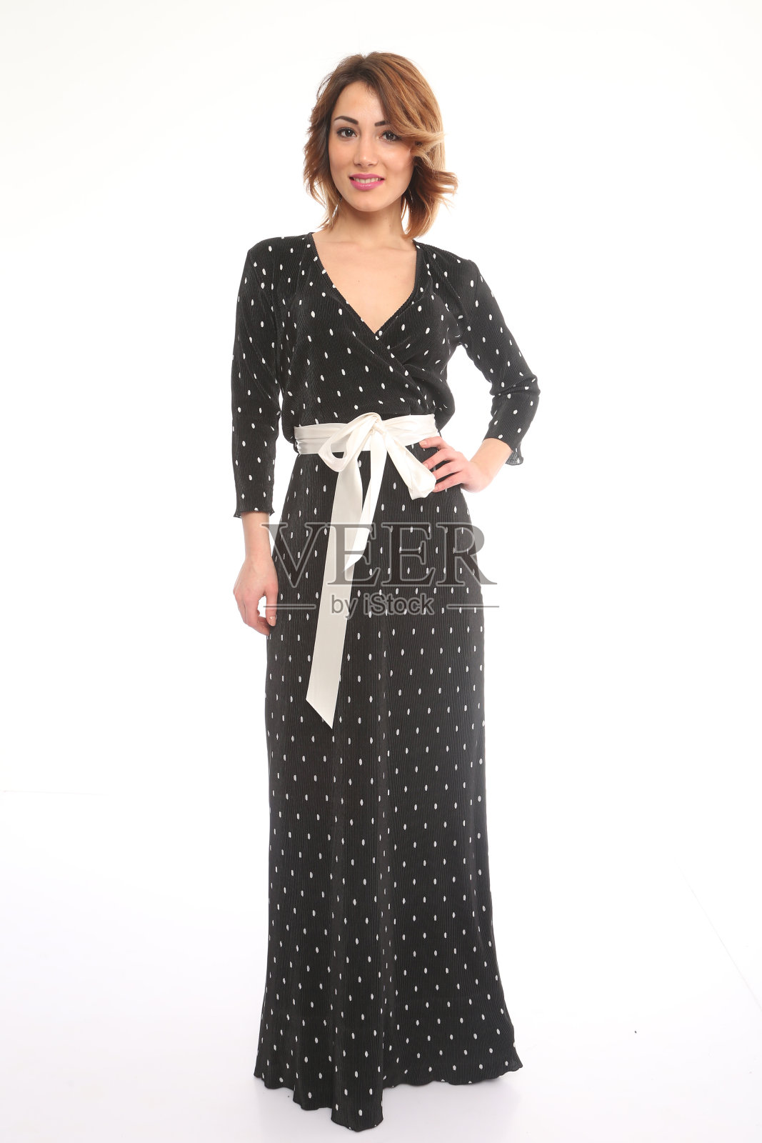 穿着黑裙，系着白腰带的漂亮年轻女子照片摄影图片