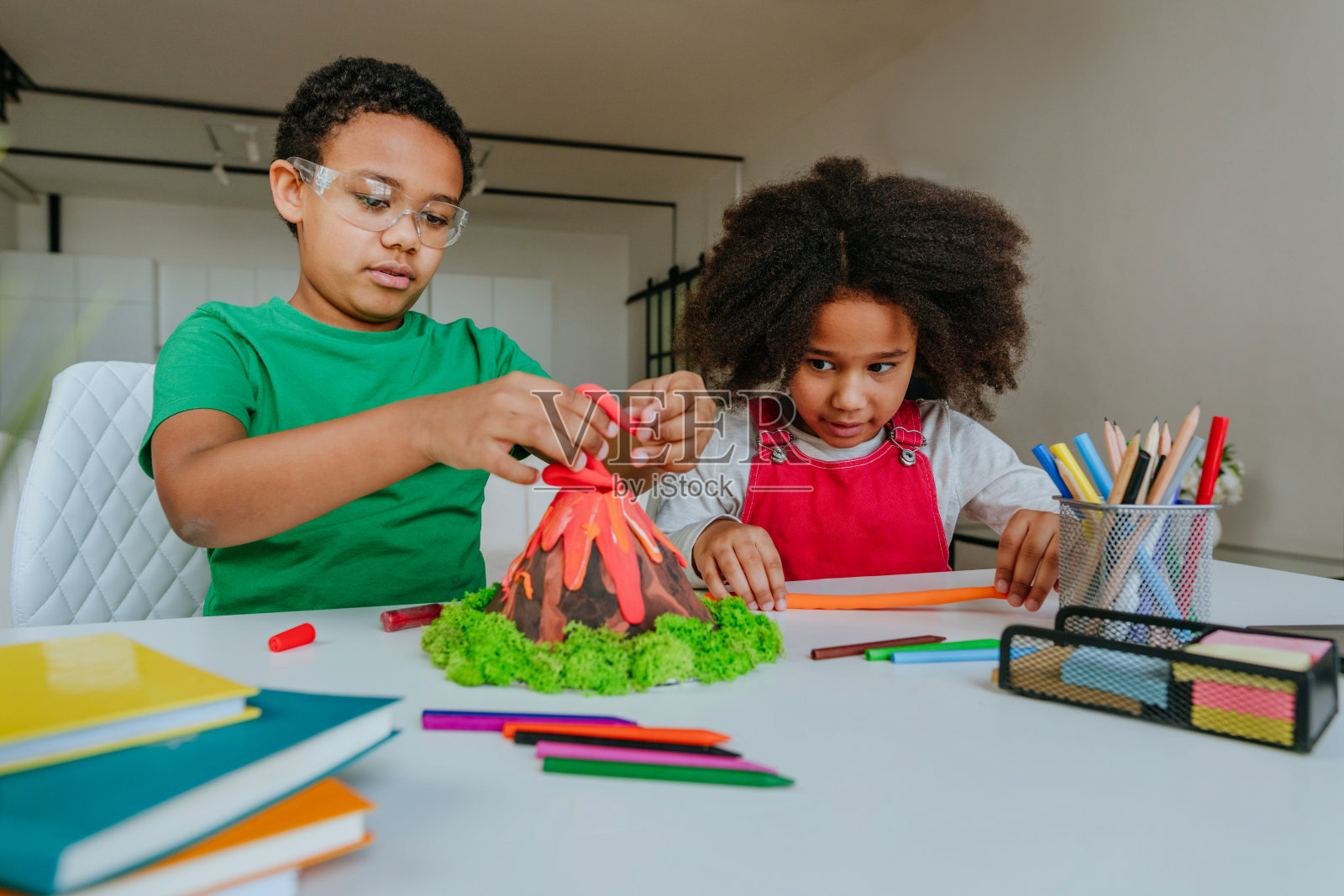 孩子们用粘土自制火山模型照片摄影图片