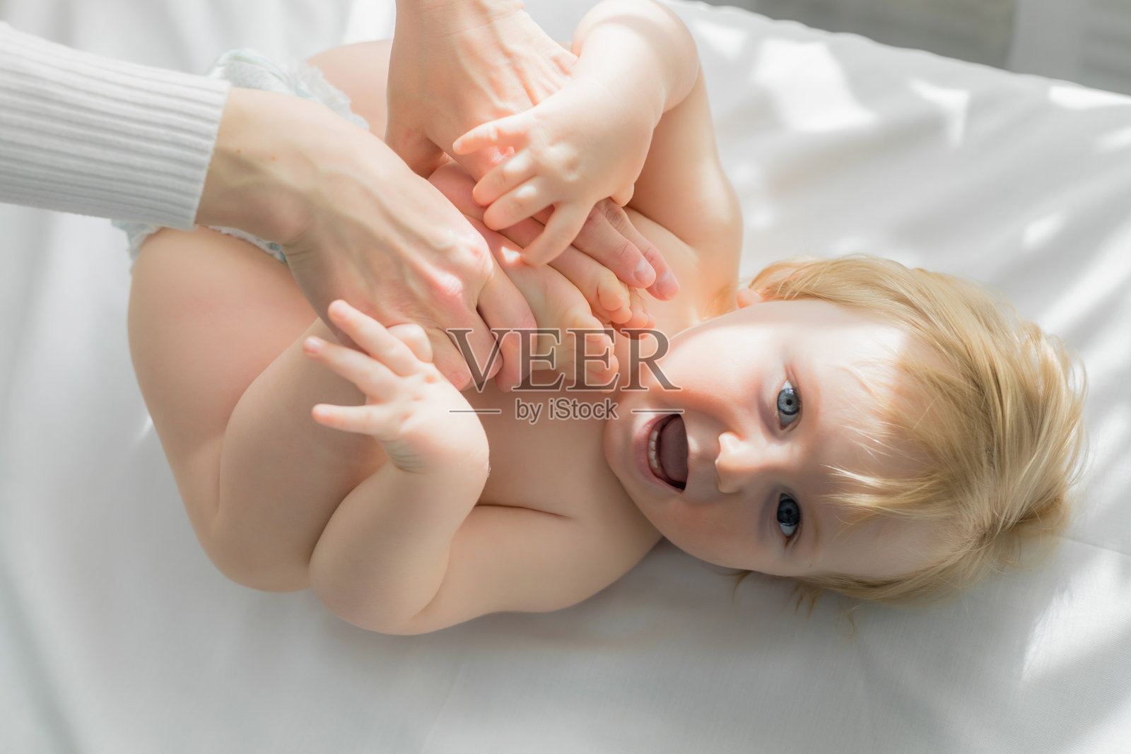 妈妈为宝宝的腿做婴儿体操。特写镜头。照片摄影图片