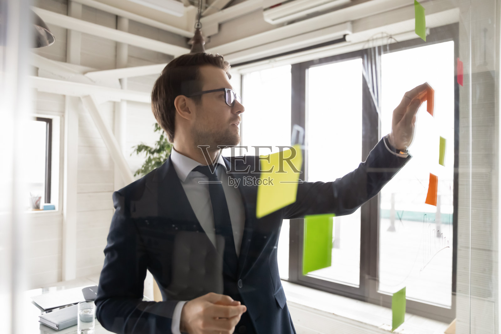 近距离观察严肃的商人戴着眼镜加粘纸照片摄影图片