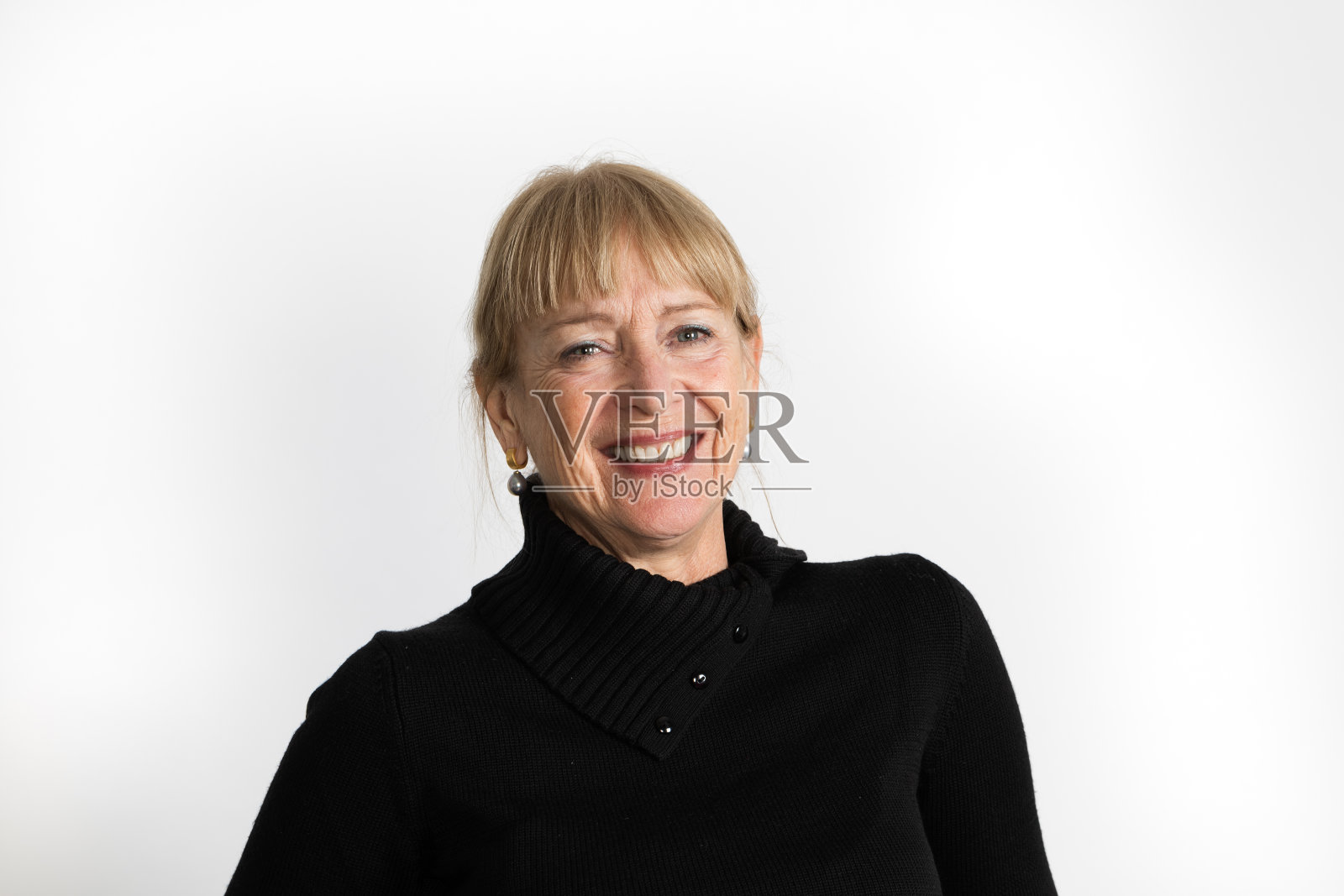 一个六十多岁穿着黑毛衣笑着的女人的半截肖像照片摄影图片