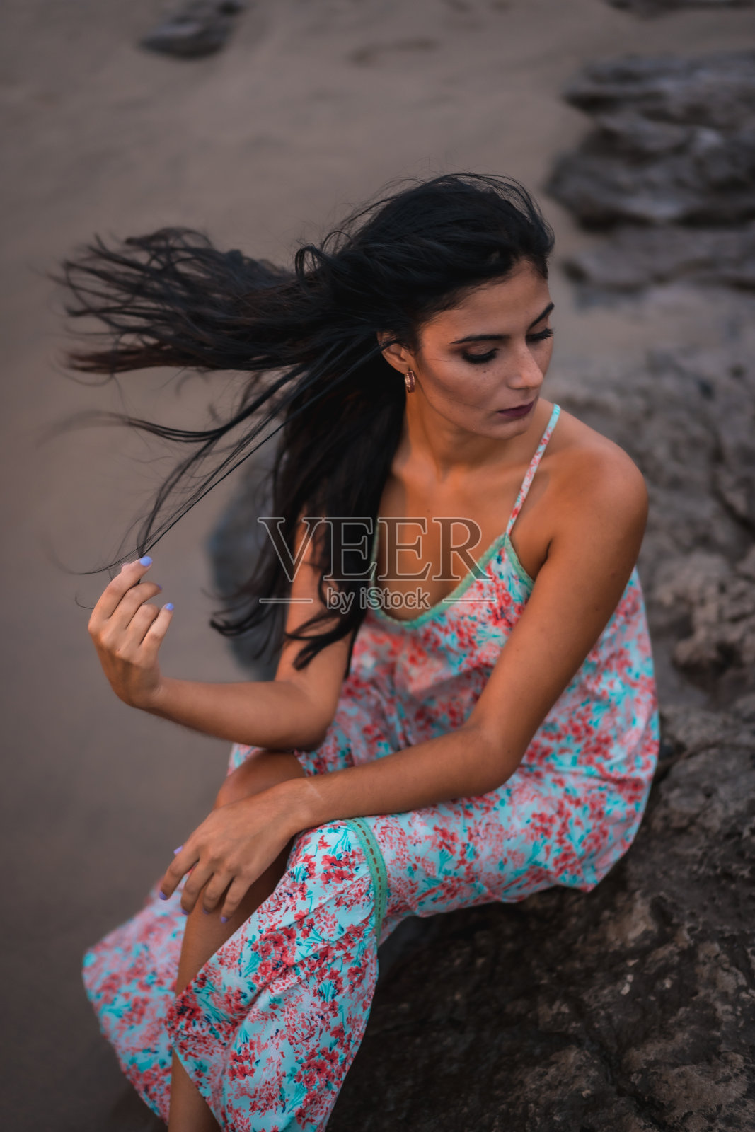 深色白种人穿着带花的白布连衣裙，在海边享受假日的沙滩上，垂直拍照照片摄影图片