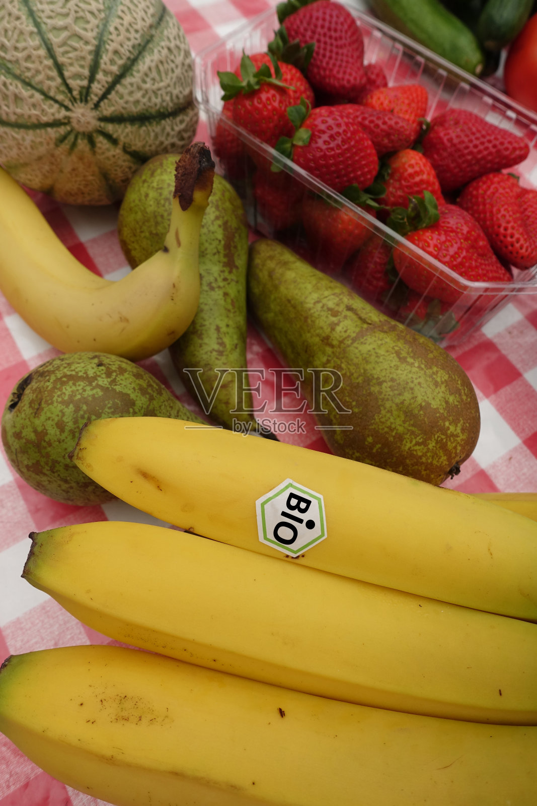 有机香蕉，梨，草莓和哈密瓜在厨房的柜台上照片摄影图片