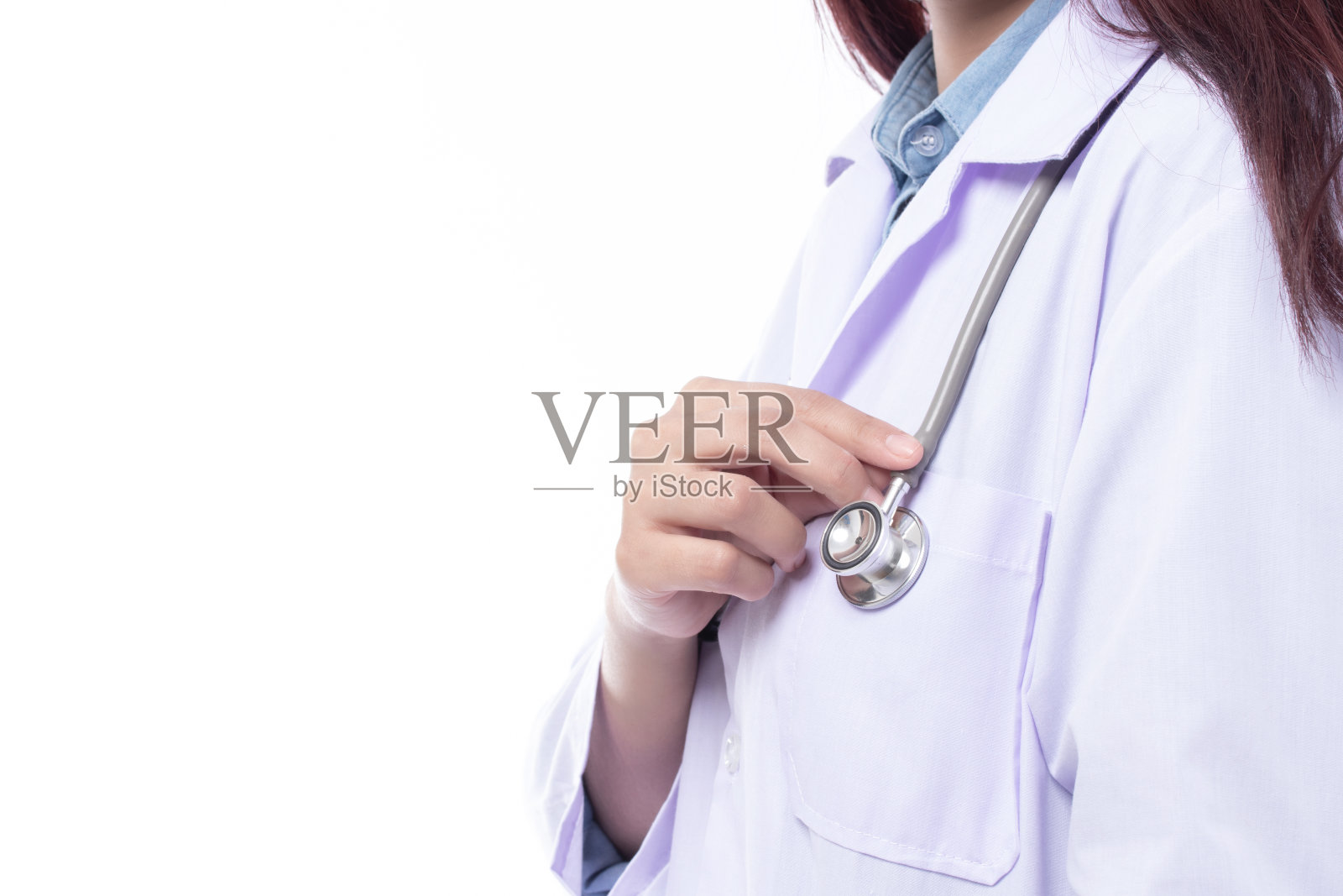 近距离拍摄在医务室手持听诊器的女医生或护士，以白色背景隔离。医疗保健和医疗理念。照片摄影图片