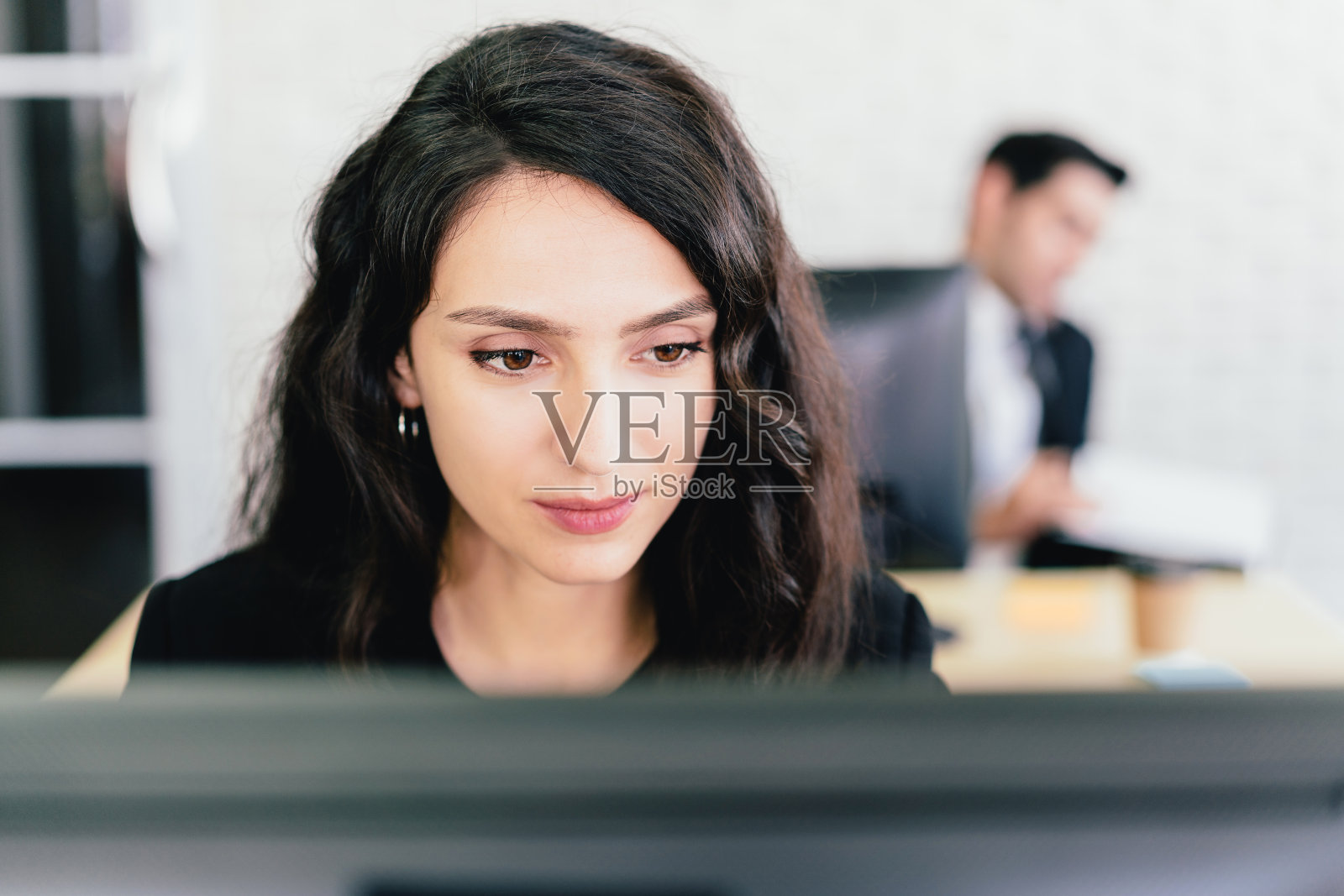 特写的一个白人女商人打字和看着电脑屏幕与意向在她的办公桌。在公司办公室关注并解决问题。照片摄影图片