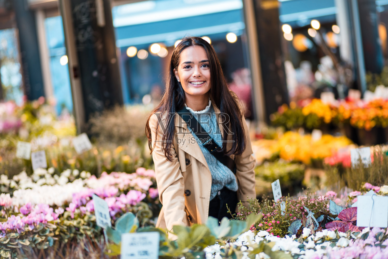 在花园中心微笑的女人。照片摄影图片