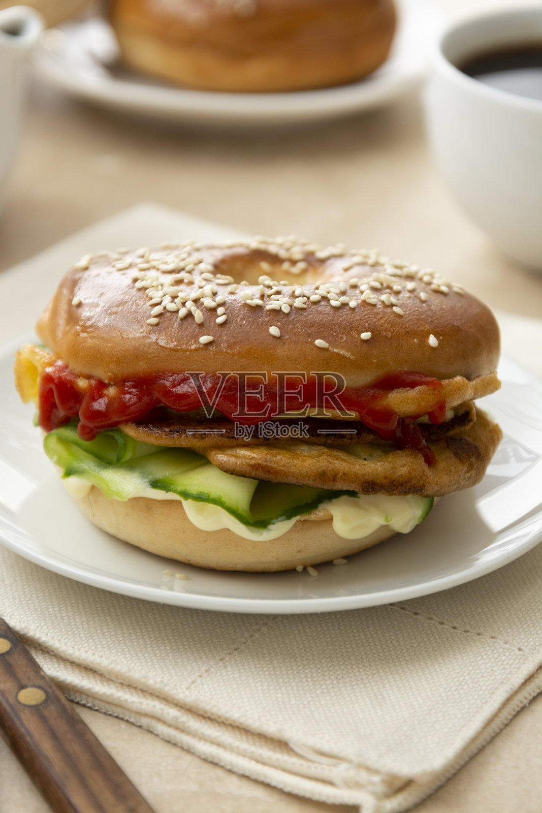 有黄瓜，沙司，鸡蛋，奶酪的百吉饼三明治。早餐或午餐，特写百吉饼面包配咖啡照片摄影图片