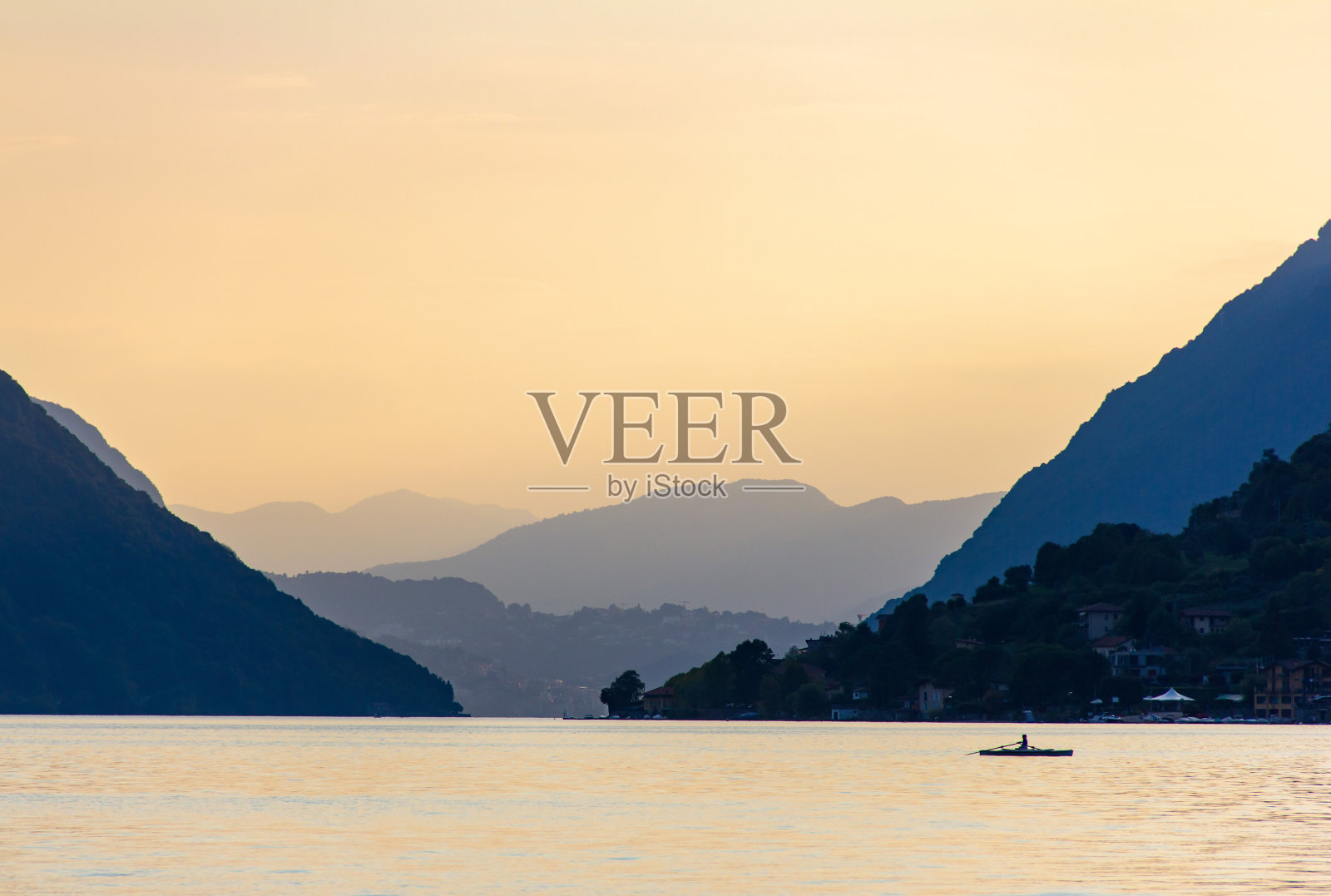 意大利波勒萨的夏季日落在山之间的卢加诺湖照片摄影图片