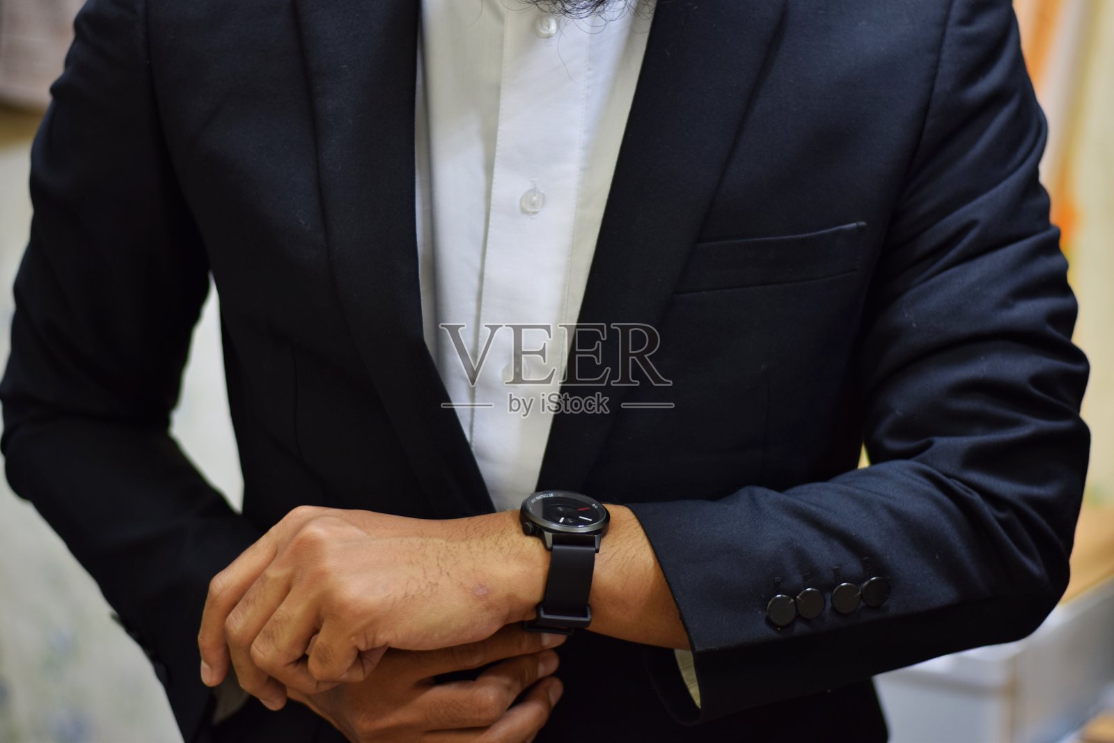 穿着西装拿着手表的男人照片摄影图片