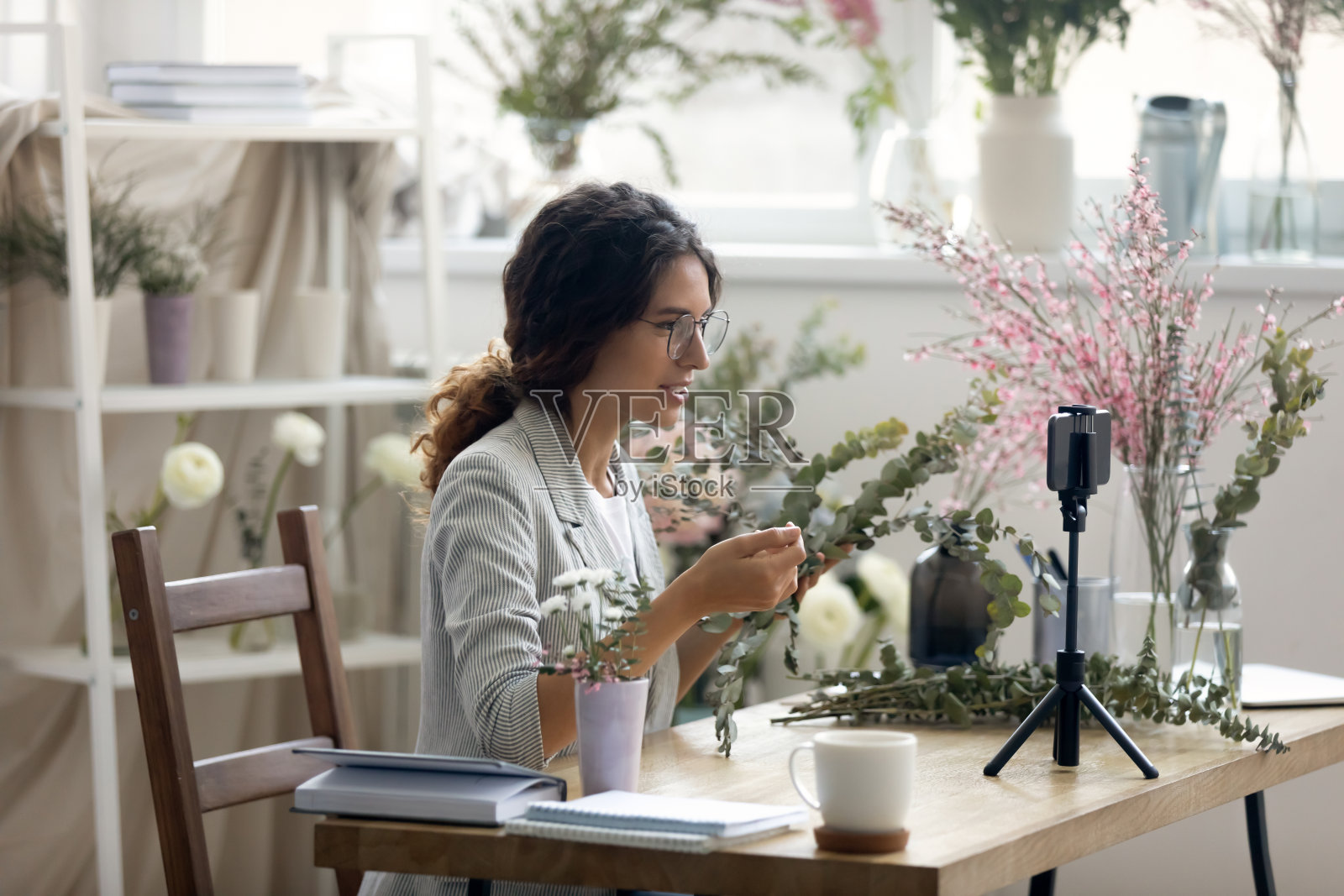 热心的年轻女子花商录制插花视频课照片摄影图片