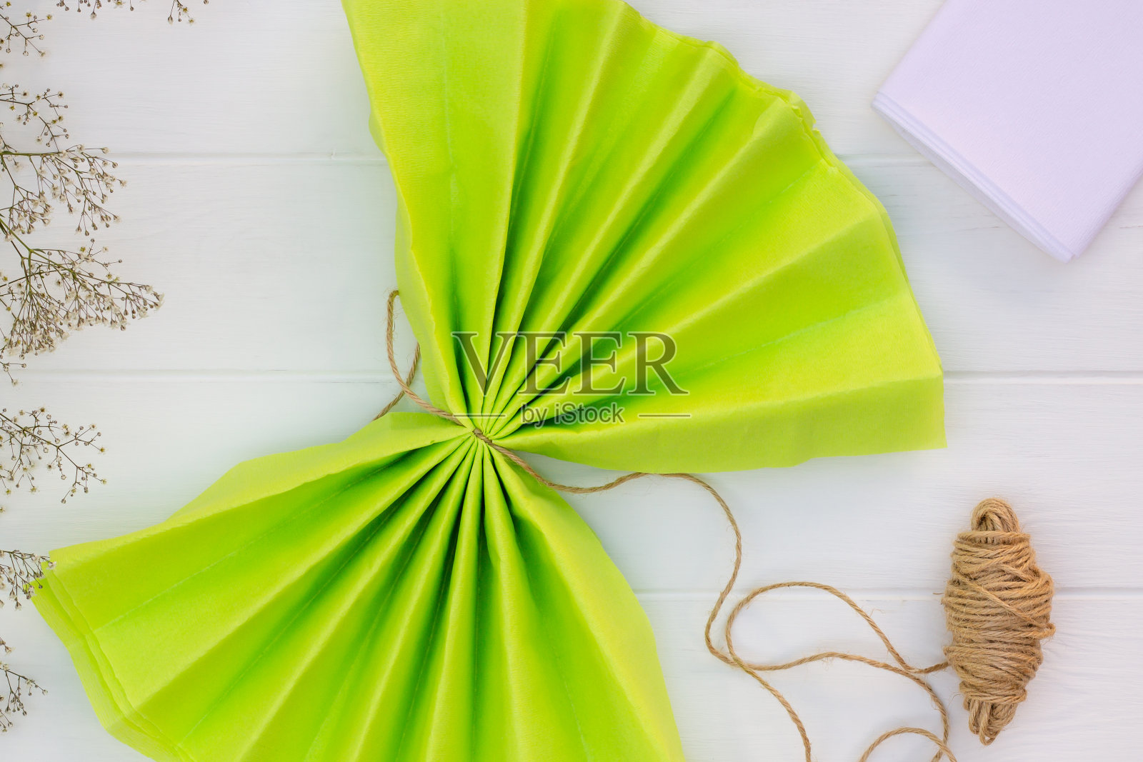 一步一步的教程，制作一个浅绿色的绒毛绒球从纸巾。前视图。步骤6照片摄影图片