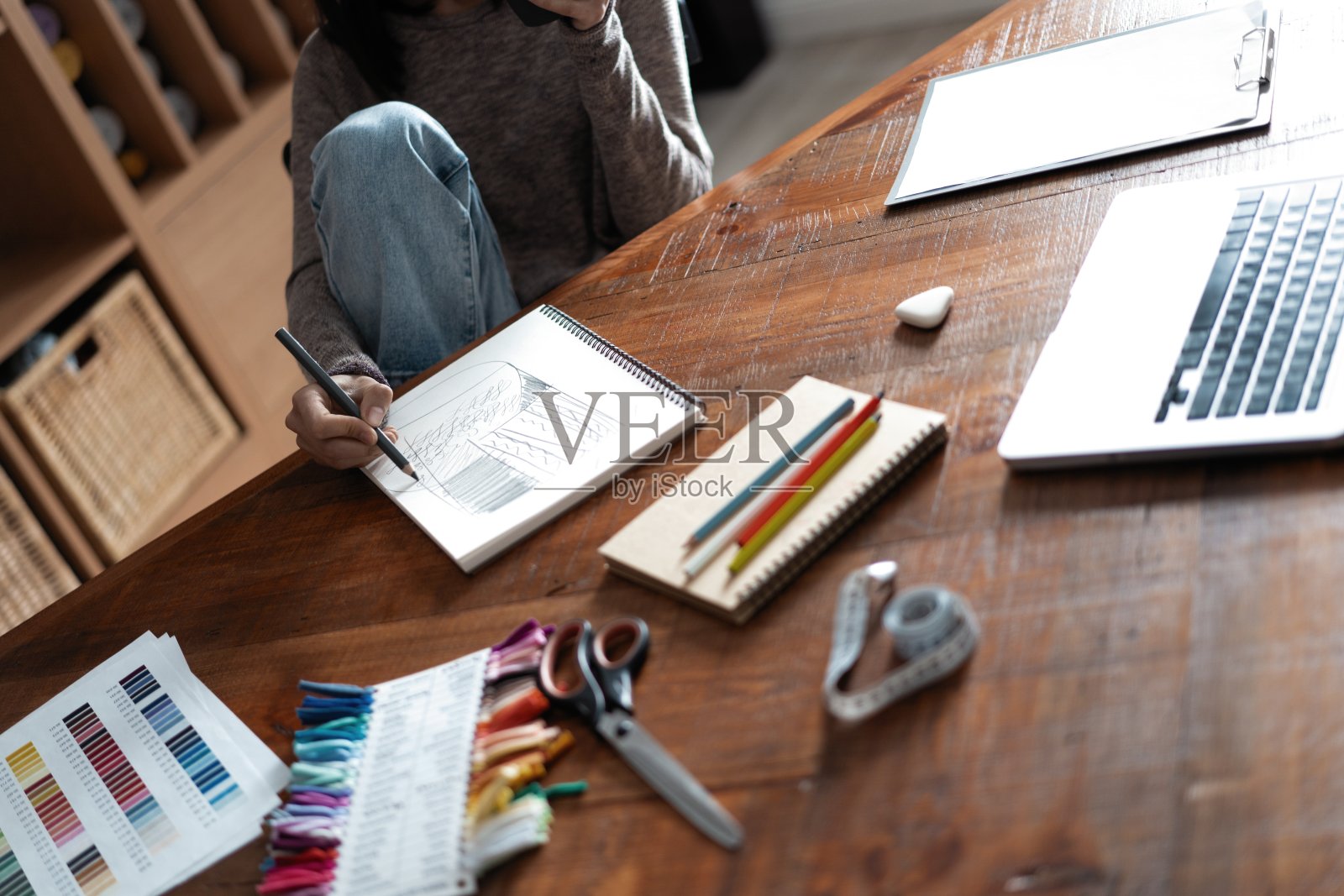 印度混血漂亮设计师在她办公室的办公桌前工作。照片摄影图片