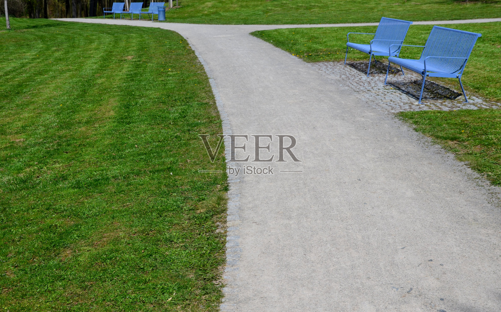 公园里的浅蓝色长椅由类似格子的金属条制成。照片摄影图片