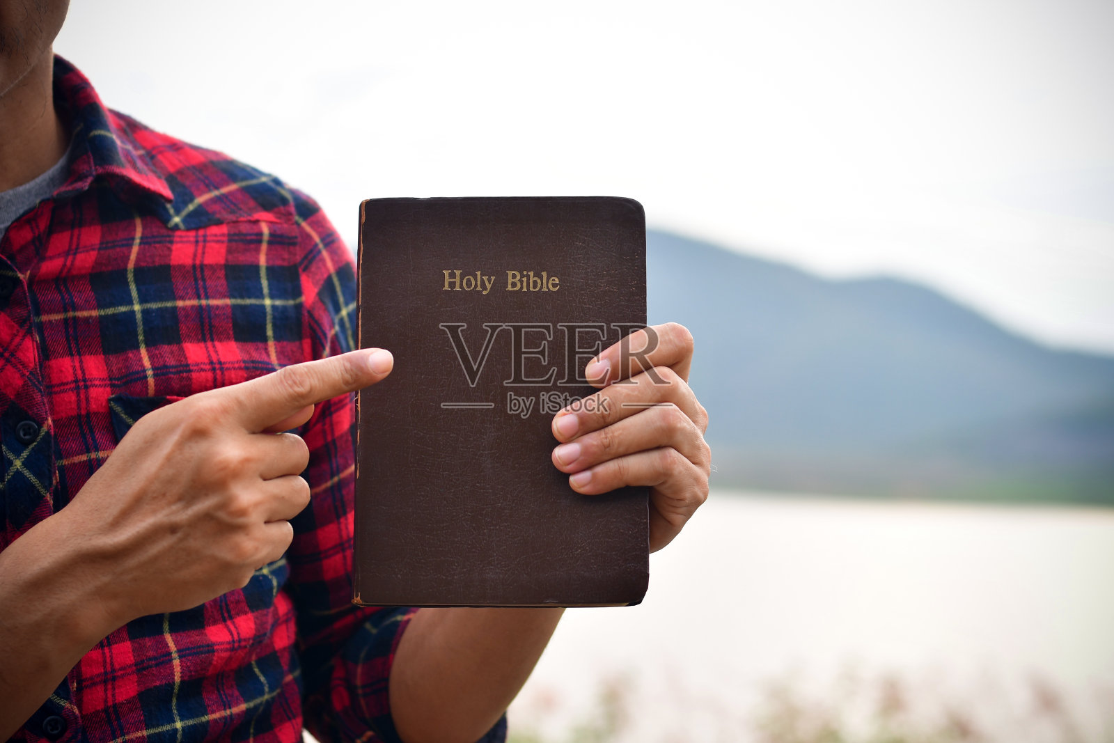 基督教徒手中拿着圣经在自然界中与抄写空间。照片摄影图片