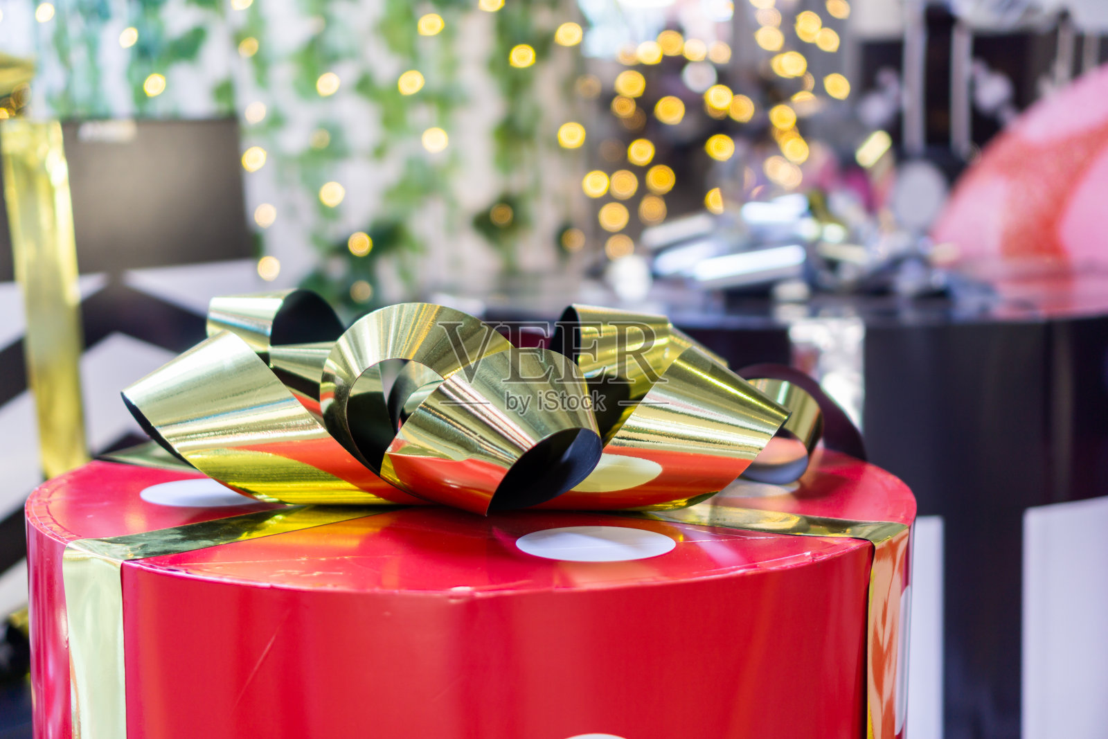 红色礼盒，白色圆点，金色蝴蝶结顶部。照片摄影图片