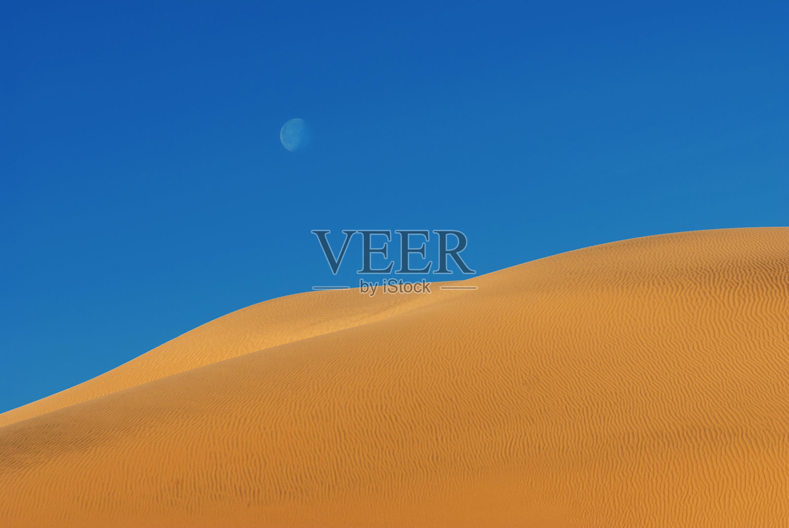 沙丘上的月亮对着蓝天照片摄影图片