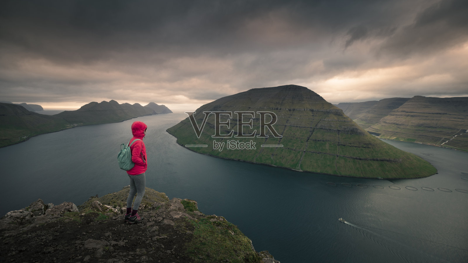 在克拉克斯维克附近的克拉库尔视点的女人与卡尔索伊和库诺伊在日落，法罗群岛照片摄影图片