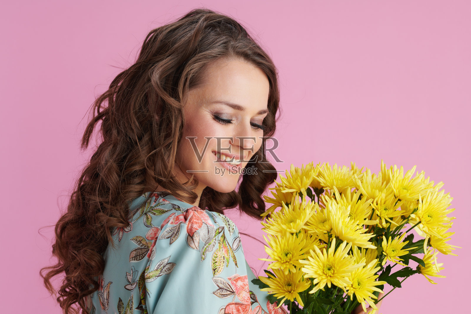快乐优雅的女性在粉红色的花裙子照片摄影图片