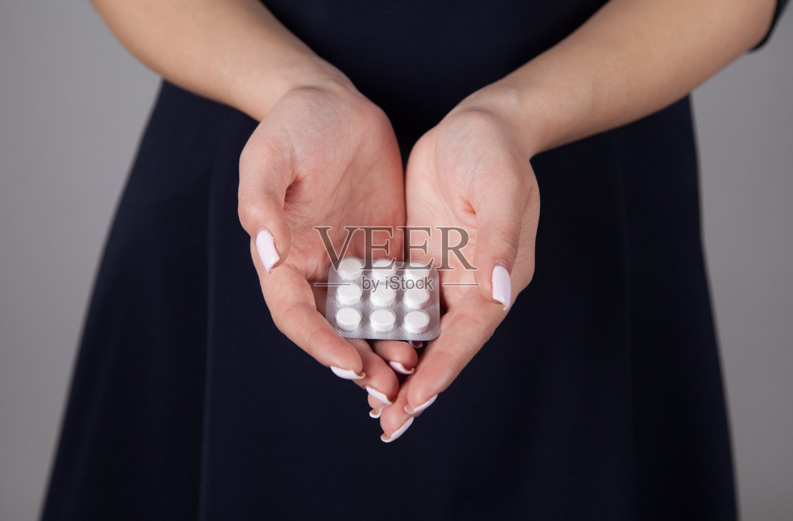 手里拿着药片的白人女人。照片摄影图片