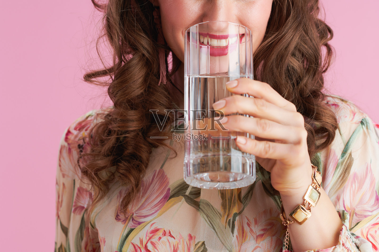 她面带微笑，有着浅黑色的长卷发照片摄影图片