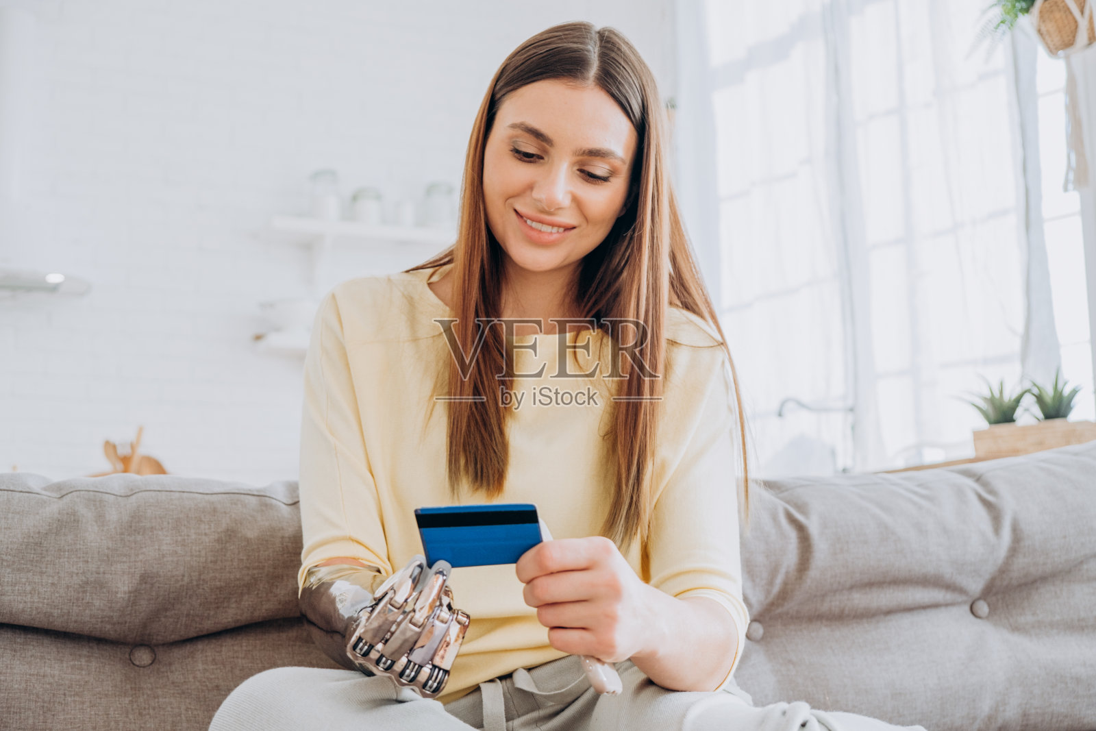 一个装假肢的女人用信用卡支付订单照片摄影图片
