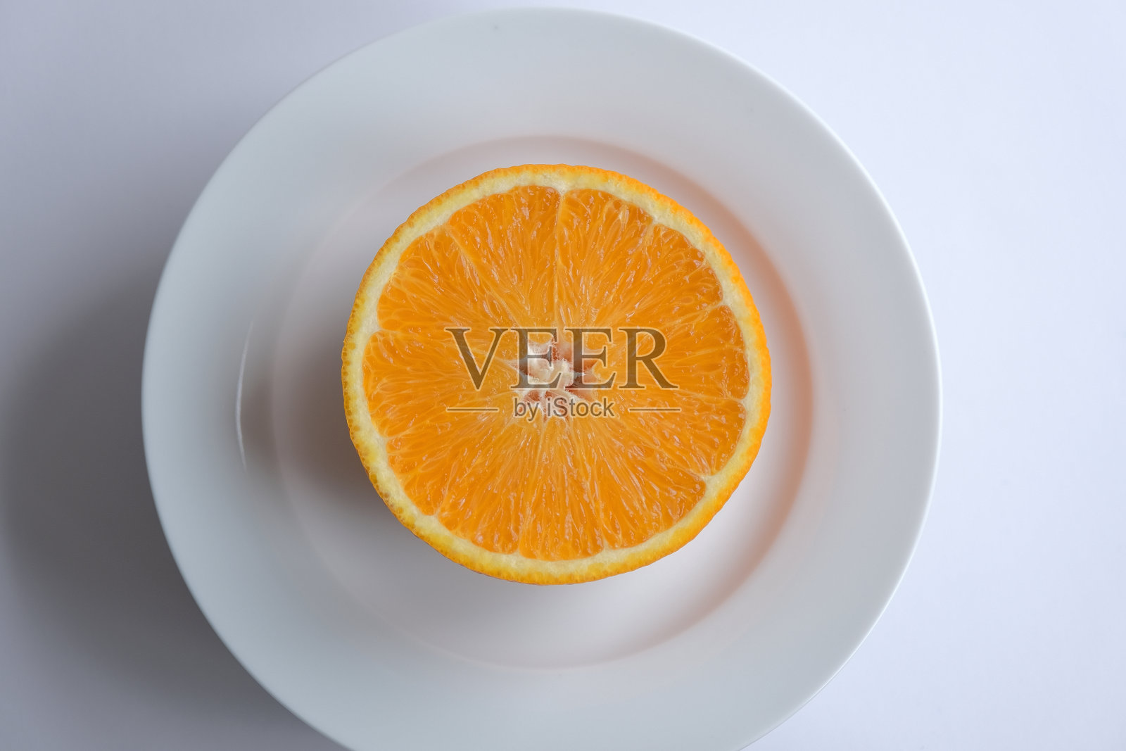 成熟多汁的橙子。新鲜的橙子切成两半，背景是带叶子的橙子照片摄影图片