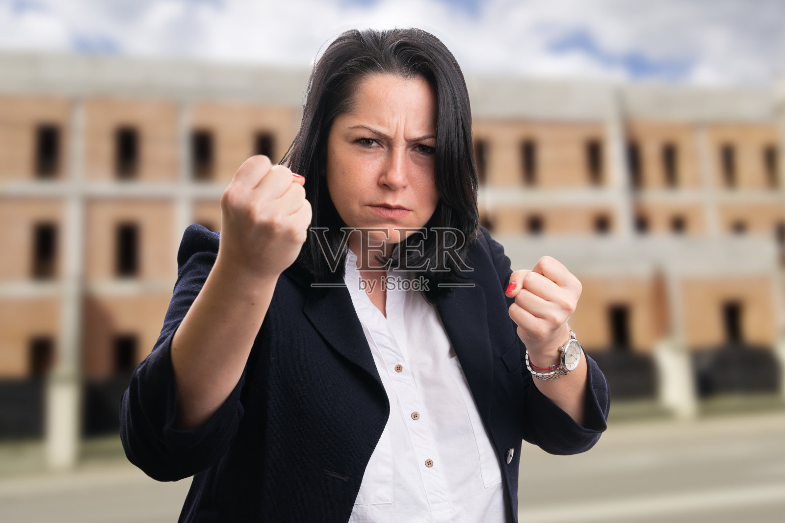 愤怒的女商人穿着西装，摆出拳头的姿势照片摄影图片