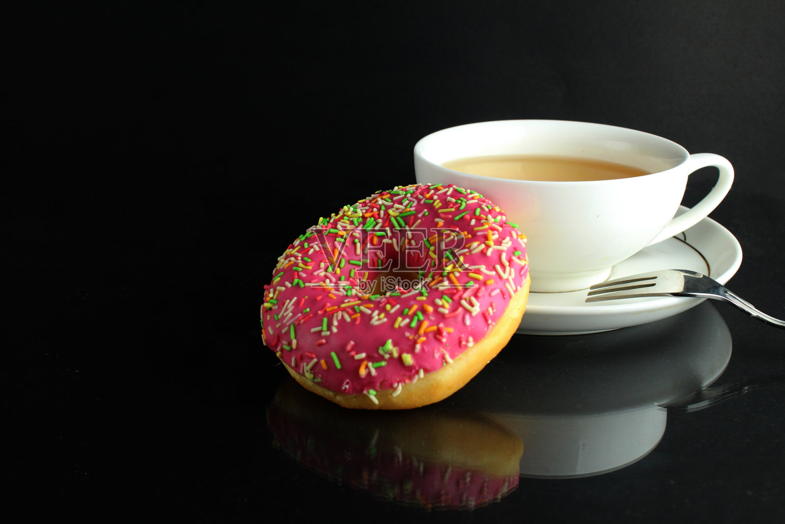 甜甜圈与粉红色的糖衣柏林躺在旁边的一杯咖啡，茶，美味的早餐，零食一天没有饮食在黑色的背景copyspace照片摄影图片