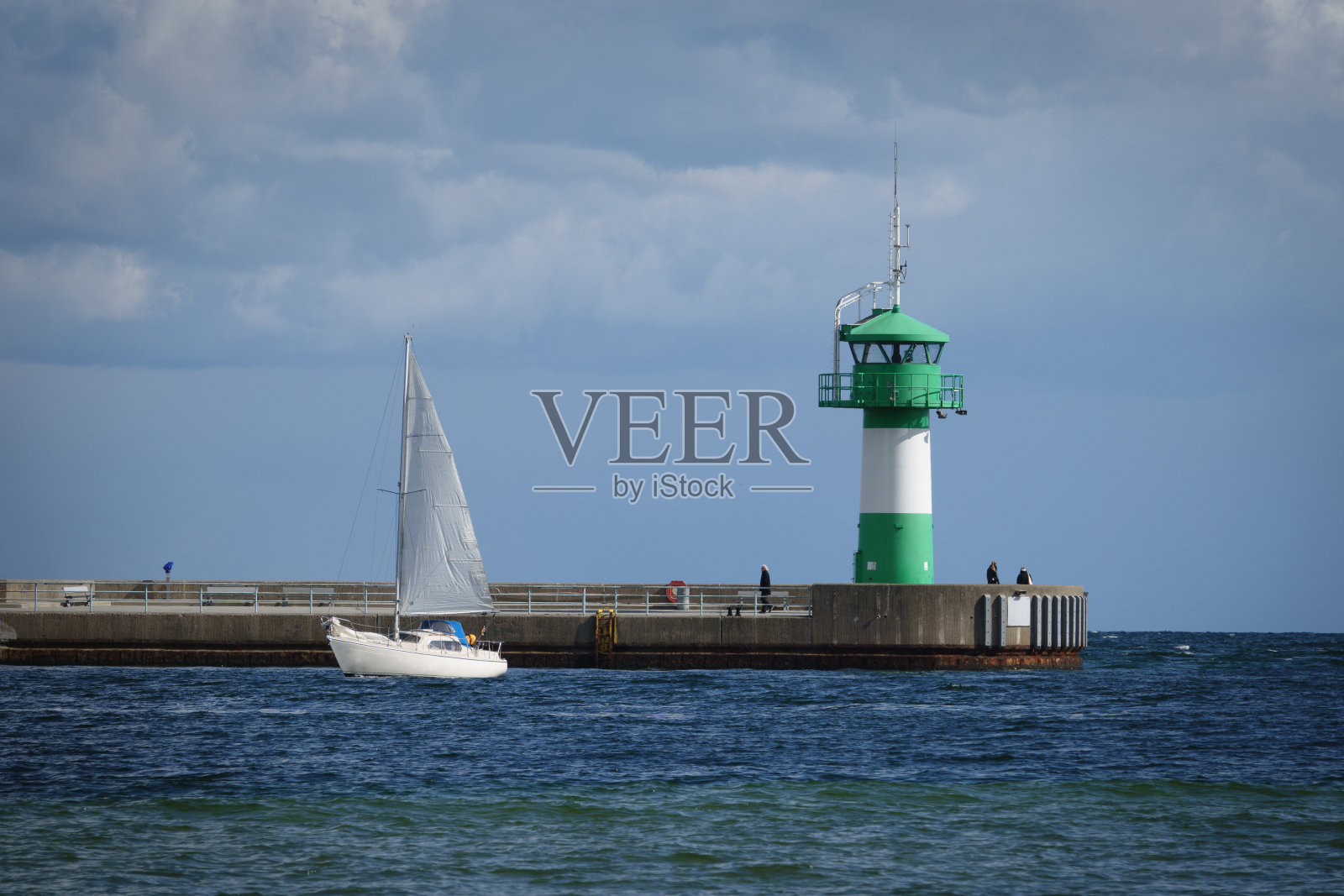 天气好时，轮船在灯塔旁经过照片摄影图片