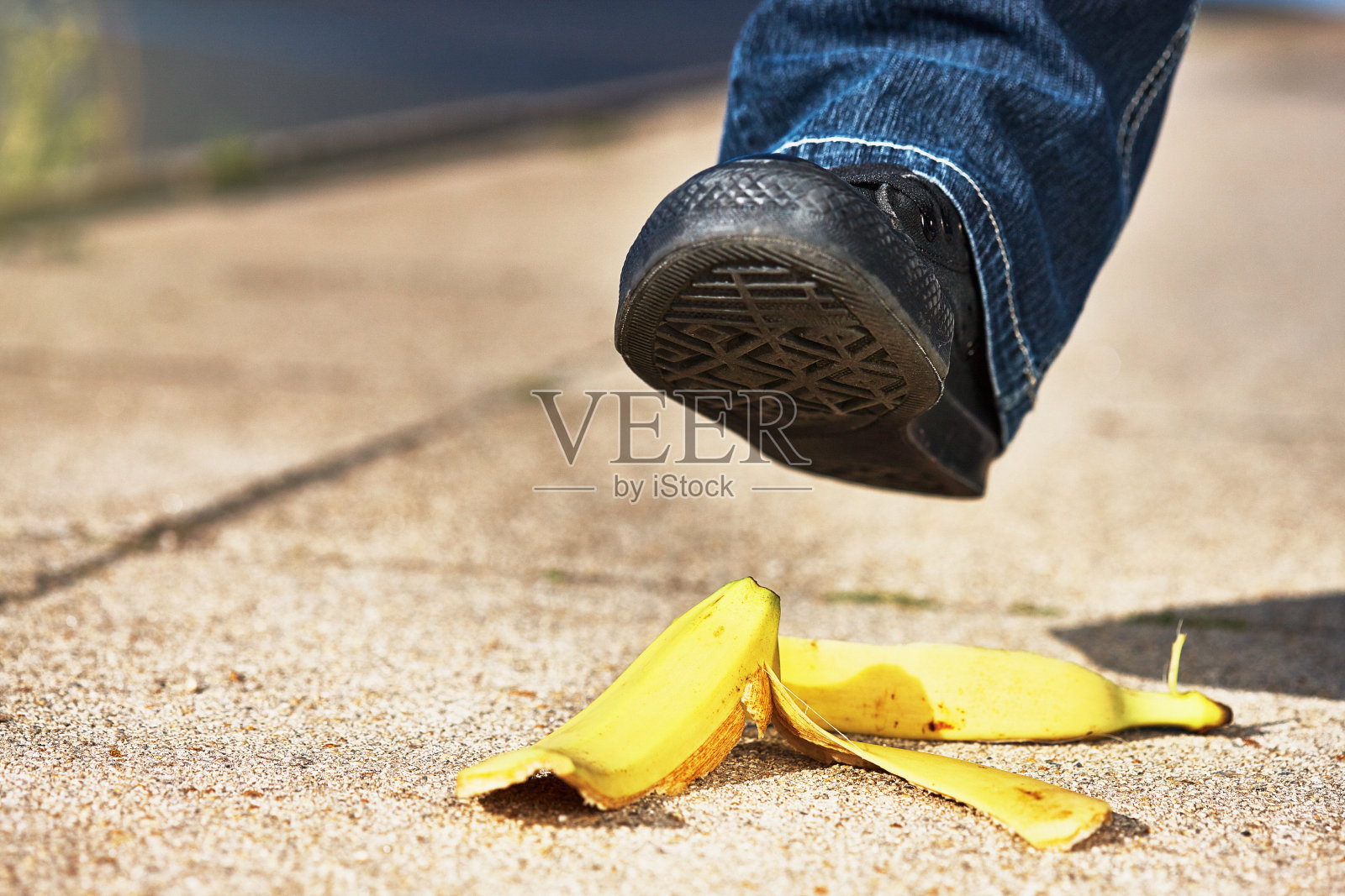 哦!在经典的事故中，人的脚差点被香蕉皮滑倒照片摄影图片