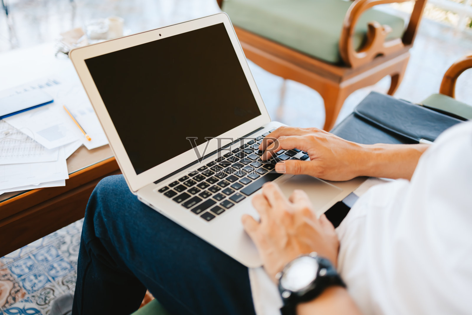 年轻的商人在咖啡店用笔记本电脑工作。商业和自由职业的工作概念。照片摄影图片