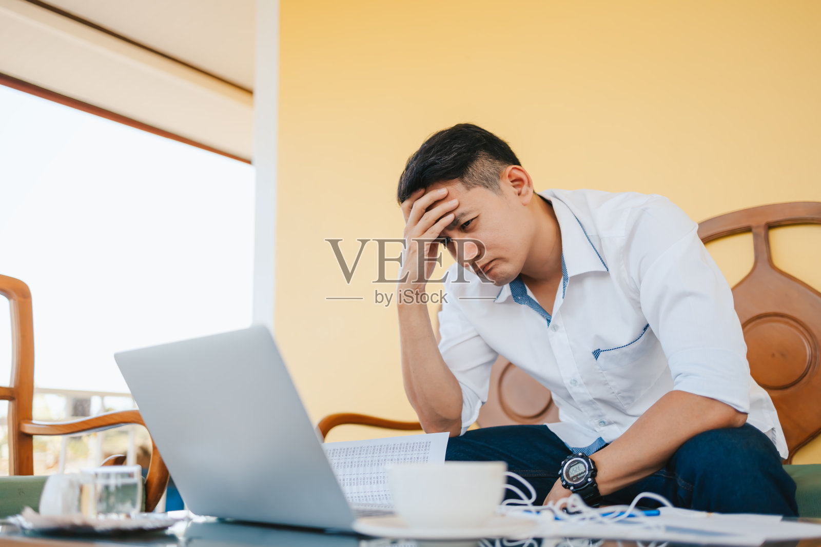 疲惫的商人在办公室里抱着他的头痛或生气。过度工作，犯错误，压力，终止，失败，不好，悲伤疲劳或抑郁的概念照片摄影图片