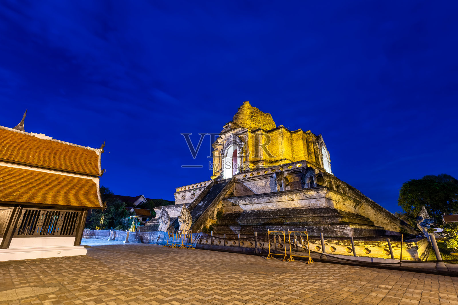 佛寺是位于历史中心的一座佛教寺庙，也是泰国清迈的一个主要旅游景点。黄昏时分，蓝天白云，夕阳背景。照片摄影图片