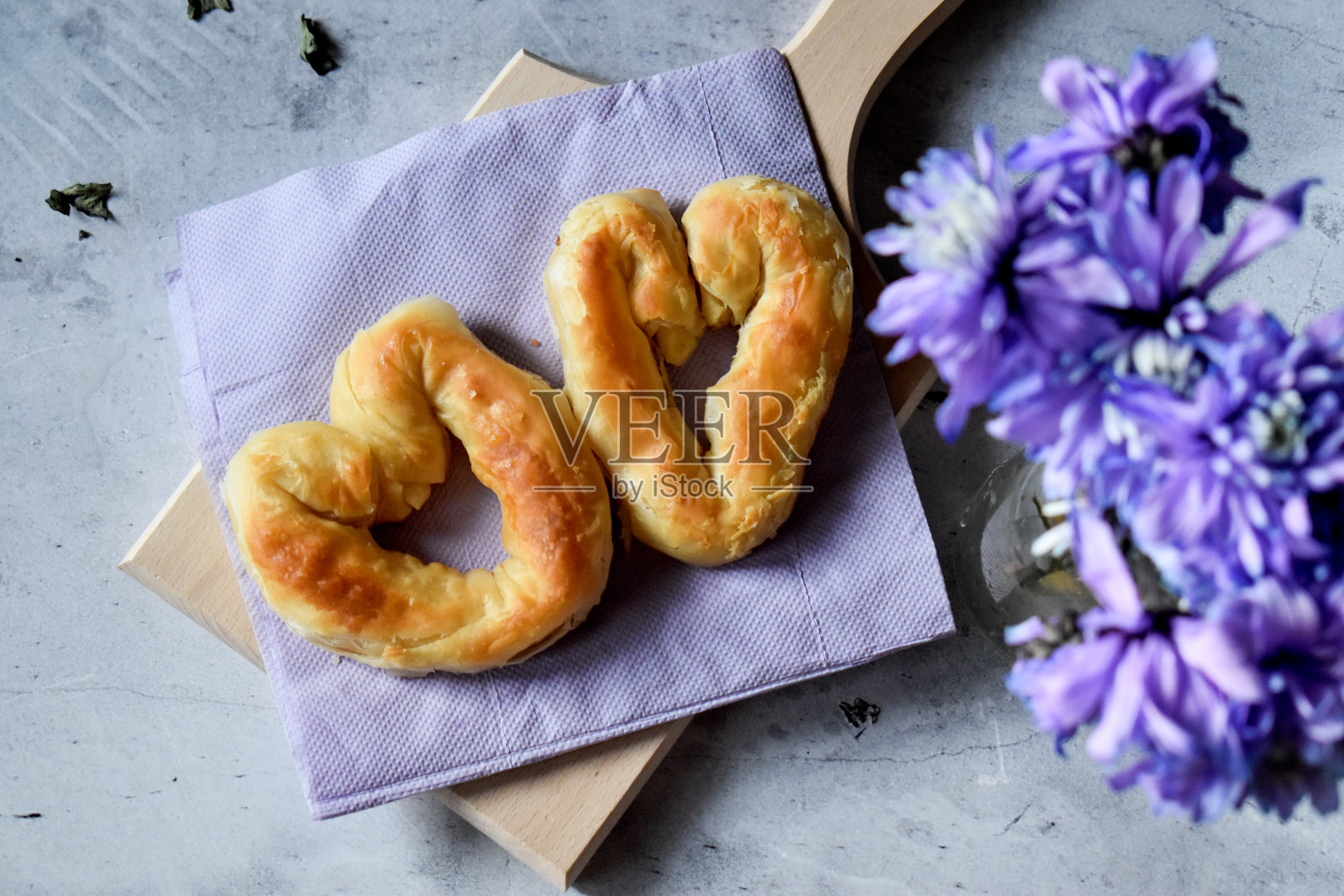 紫色餐巾上的酥皮和紫色的花照片摄影图片