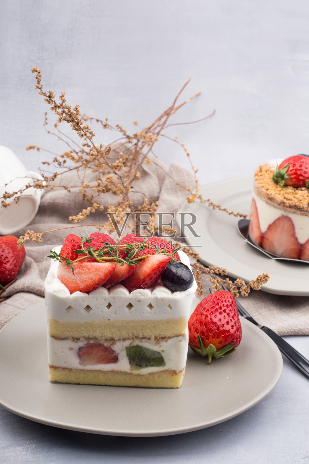 新鲜草莓蛋糕与奶油在近景。照片摄影图片