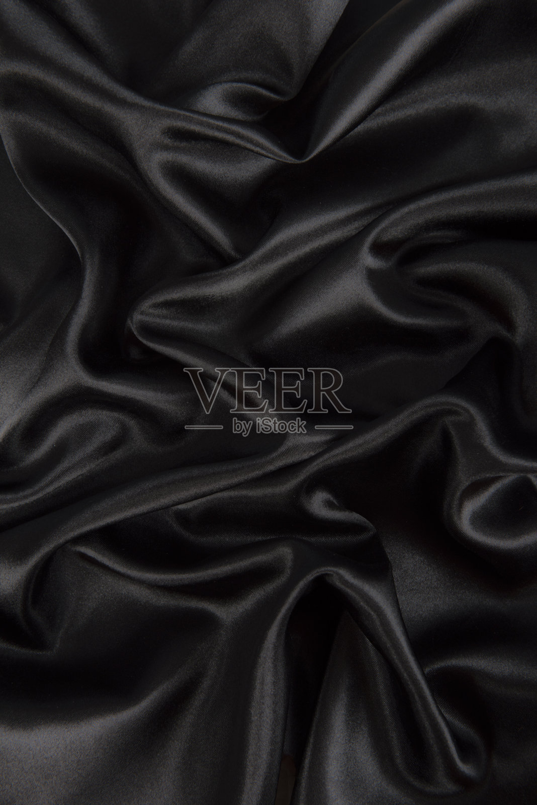 抽象的黑色丝织物背景。布料柔软的波。折痕的缎照片摄影图片