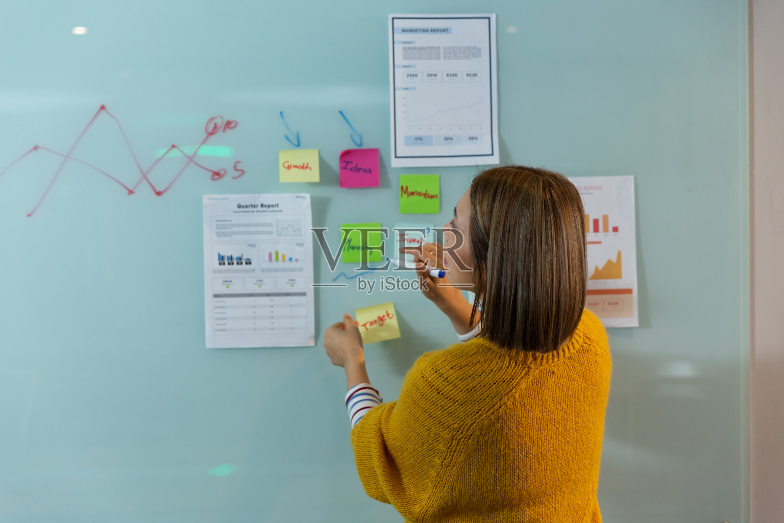 亚洲女商人站在白板前书写和放置备忘录照片摄影图片