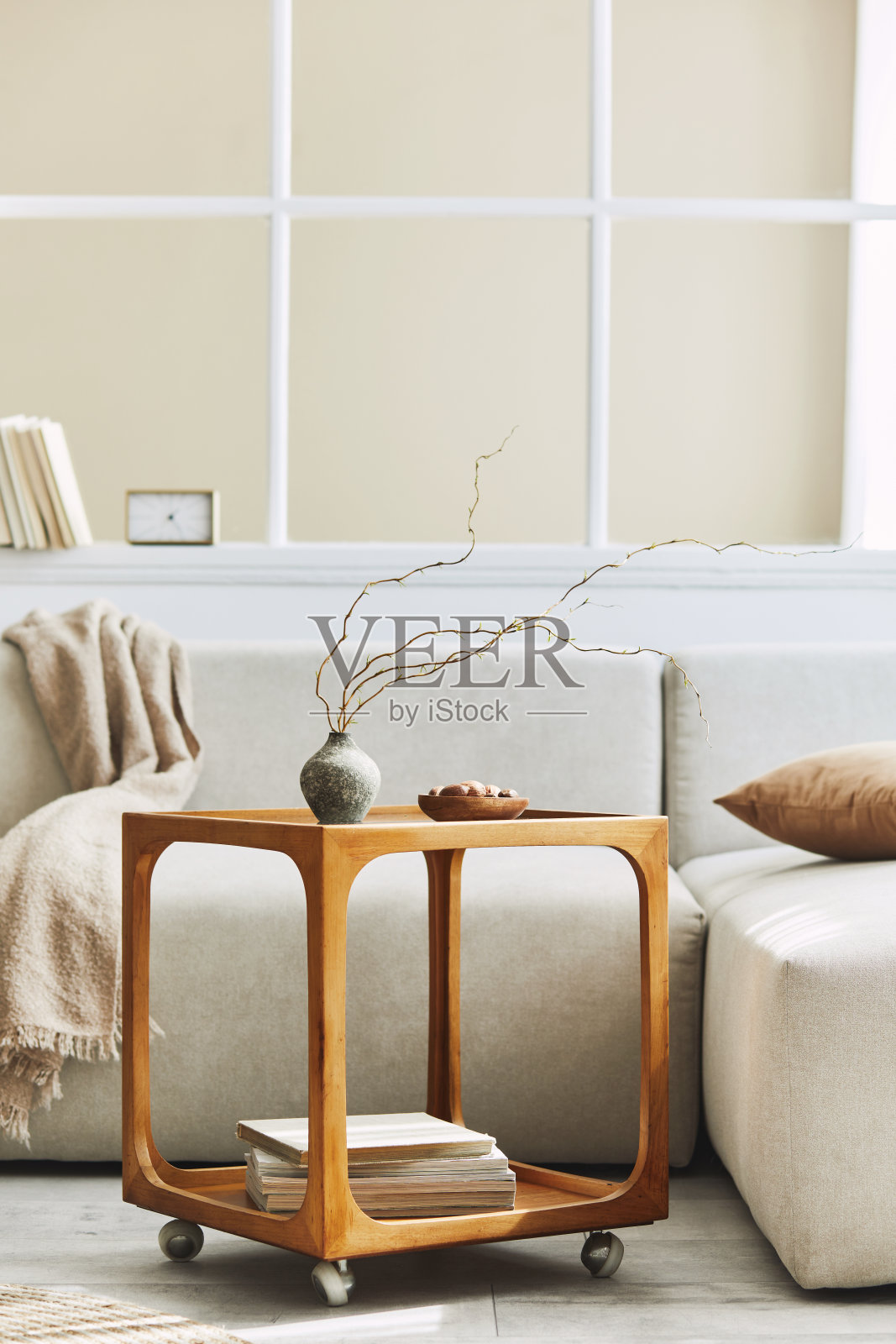 客厅内部采用极简的构图，中性的沙发，设计的木质边桌，花瓶中的干花，枕头，窗户，装饰和优雅的个人饰品在家居装饰。模板照片摄影图片