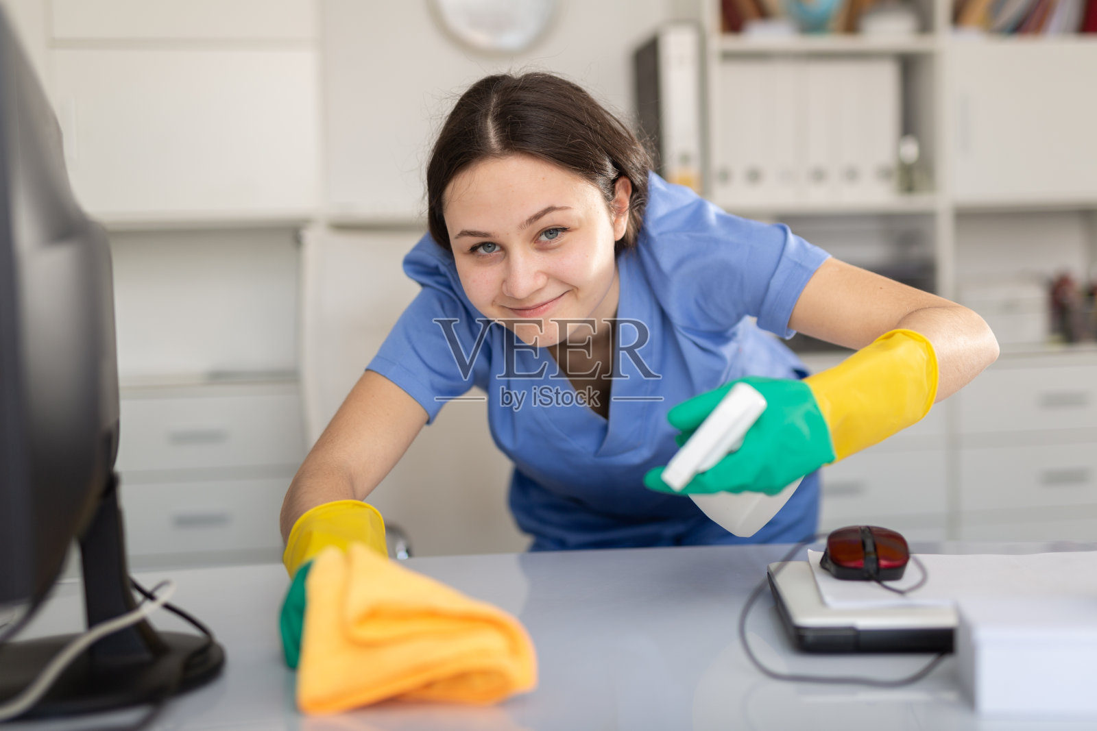 清洁公司的清洁工擦拭办公室桌子上的灰尘照片摄影图片