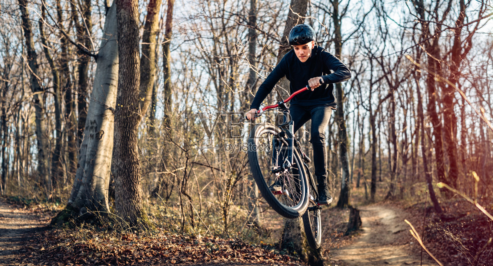 极限山地摩托车在森林轨道上跳跃照片摄影图片