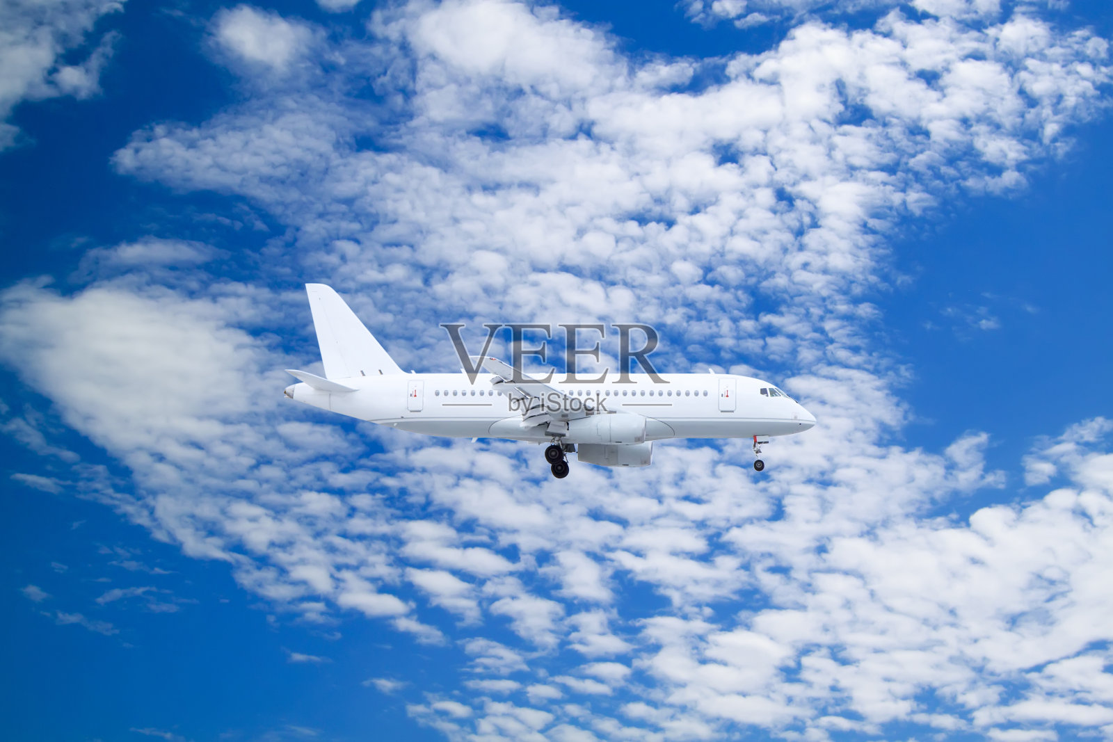 白色的客机在白云和蓝天的自然背景下降落照片摄影图片