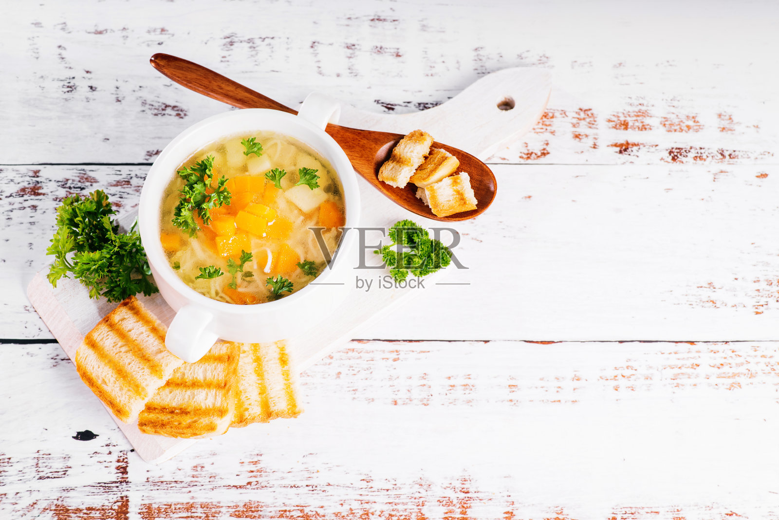 用木勺装在木板上的意大利面和蔬菜汤。特写镜头。照片摄影图片